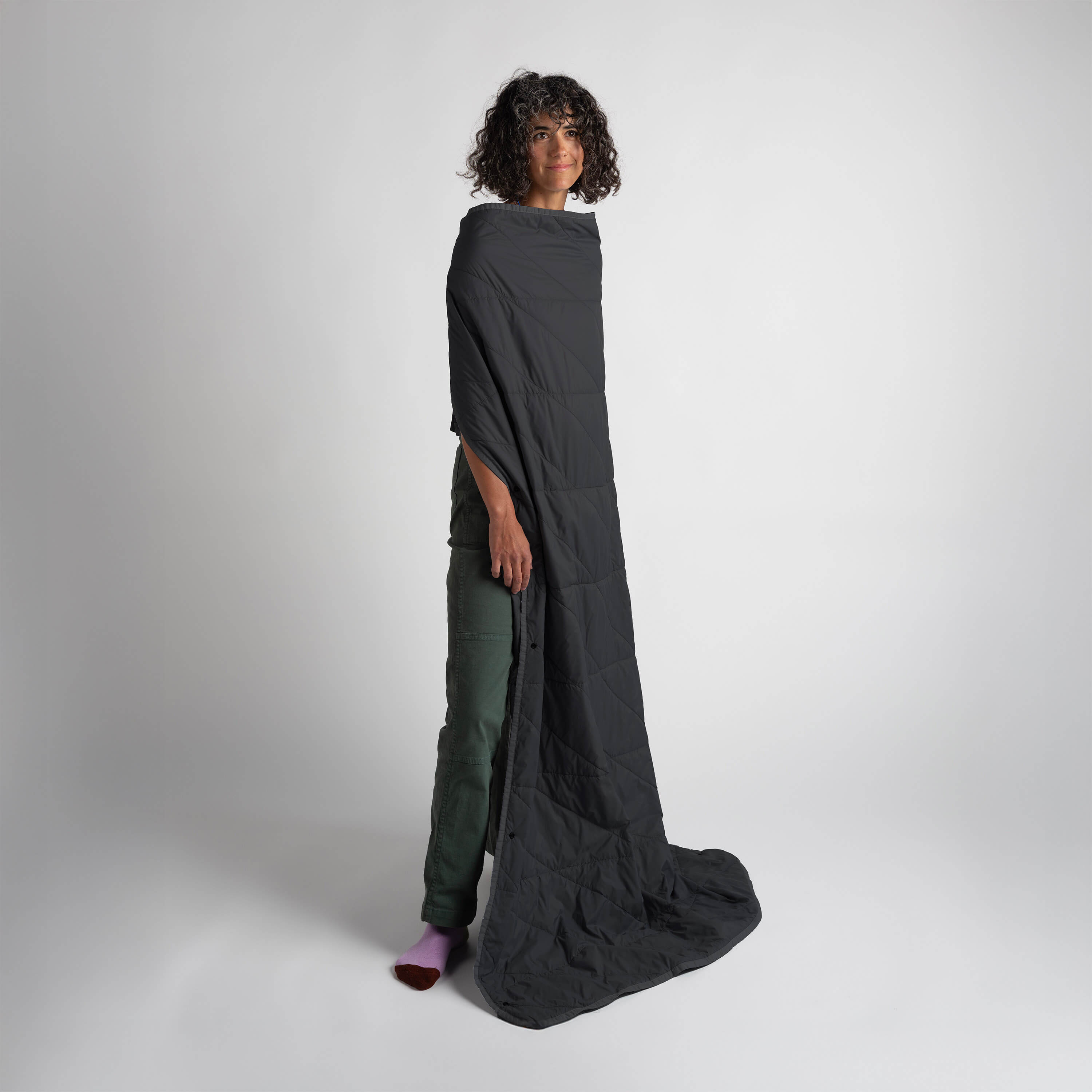Gravel Layover™ Black travel blanket spread out on a surface, showcasing its soft fabric and compact design for comfortable travel.