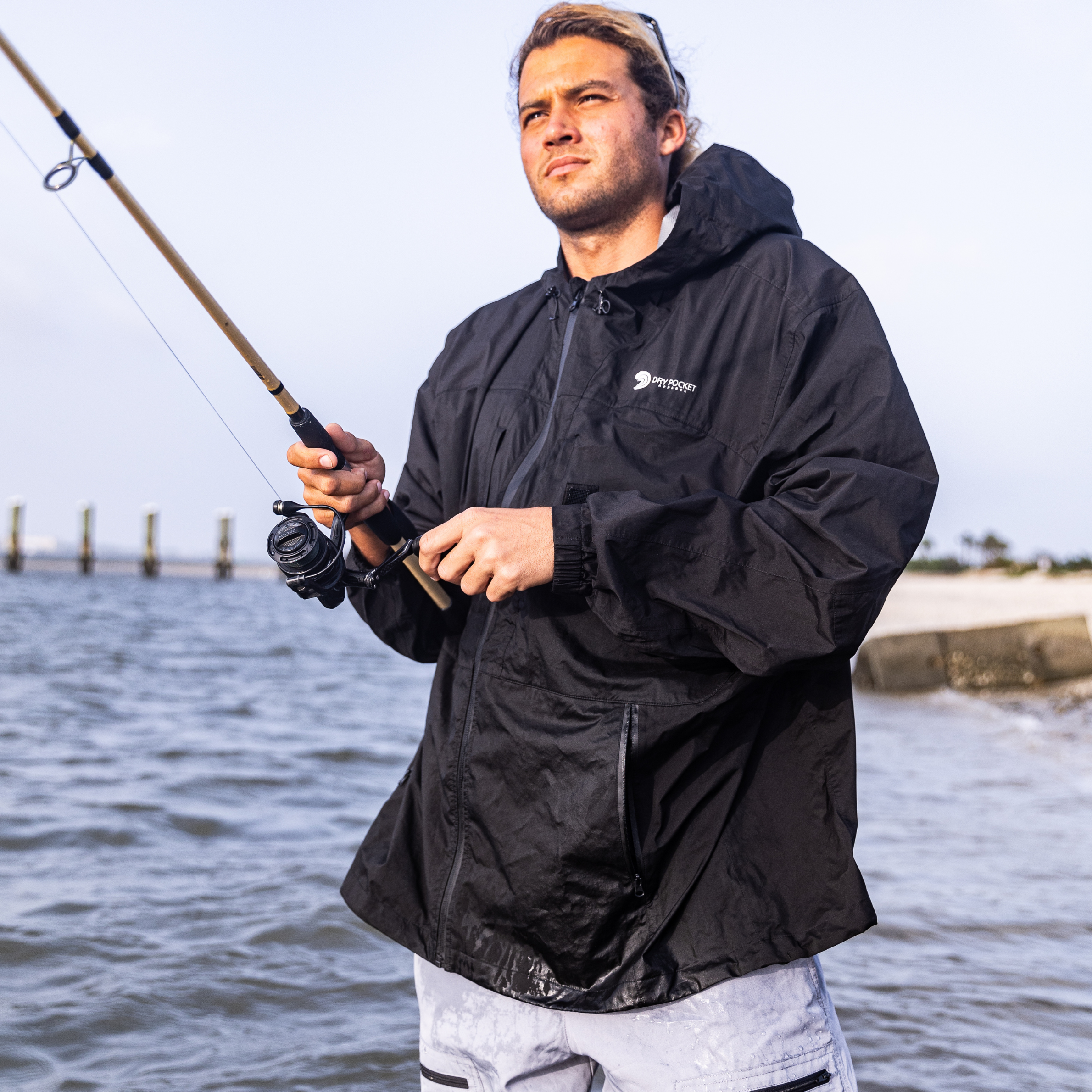 Black Dry Pocket waterproof rain jacket with a visible waterproof pocket designed for fishing and outdoor rain protection.