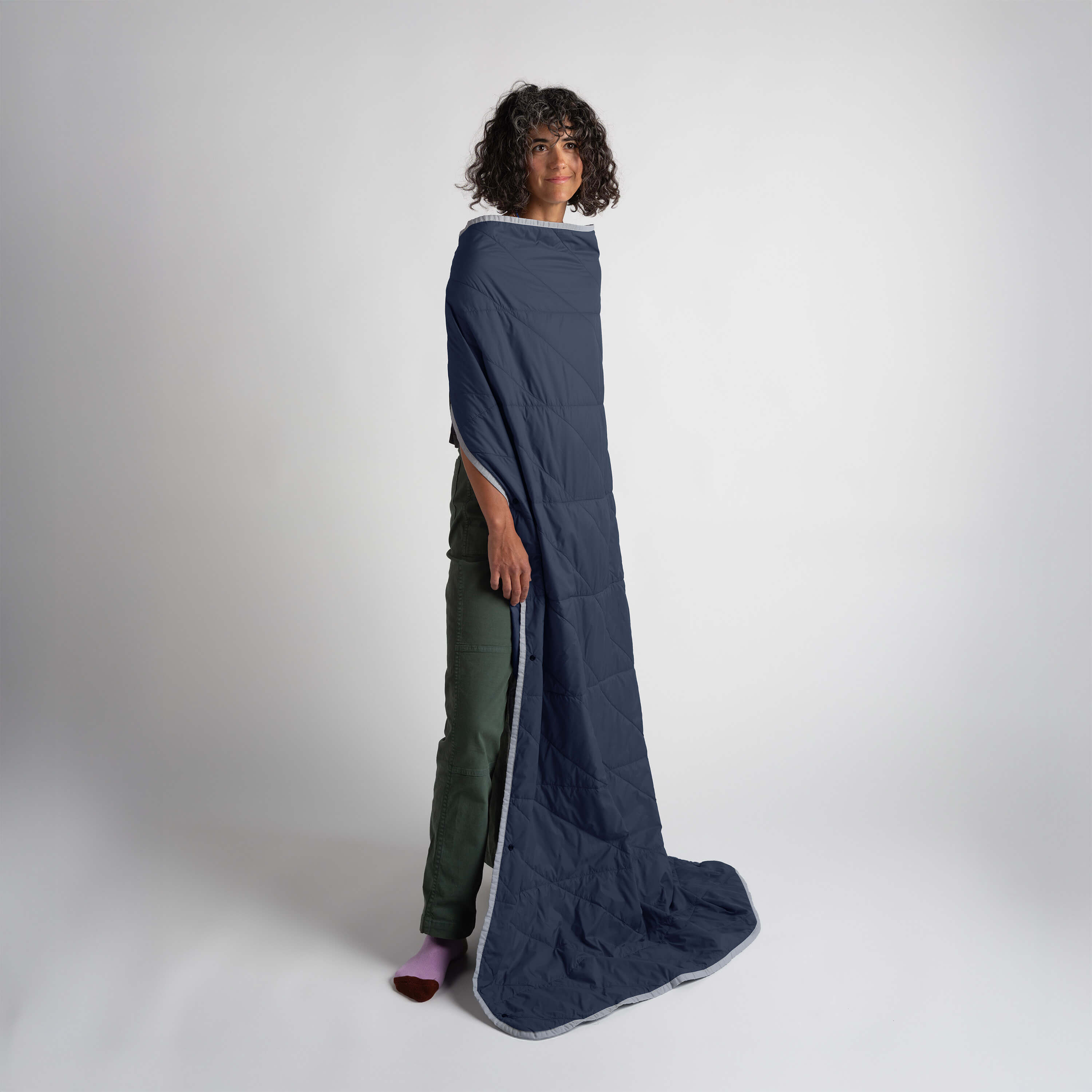 Blue Gravel Layover™ travel blanket spread out, showing soft fabric and cozy design, perfect for on-the-go comfort.