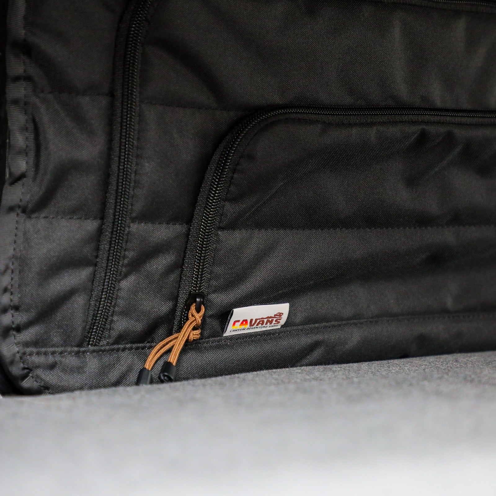 Canyon Adventure Vans CLIMA-SHADE™ insulated bunk window cover from CAV branded products, showing a black fabric cover on a van window.