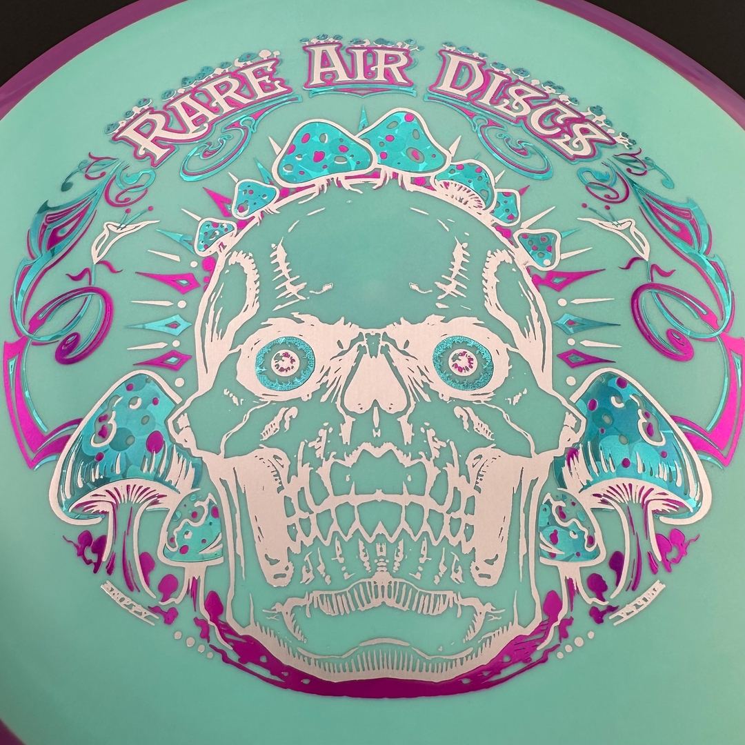 Rare Air Discs Fission Defy Crushin' Amanitas VIP 2.0 disc golf disc with vibrant orange and black design on a white background
