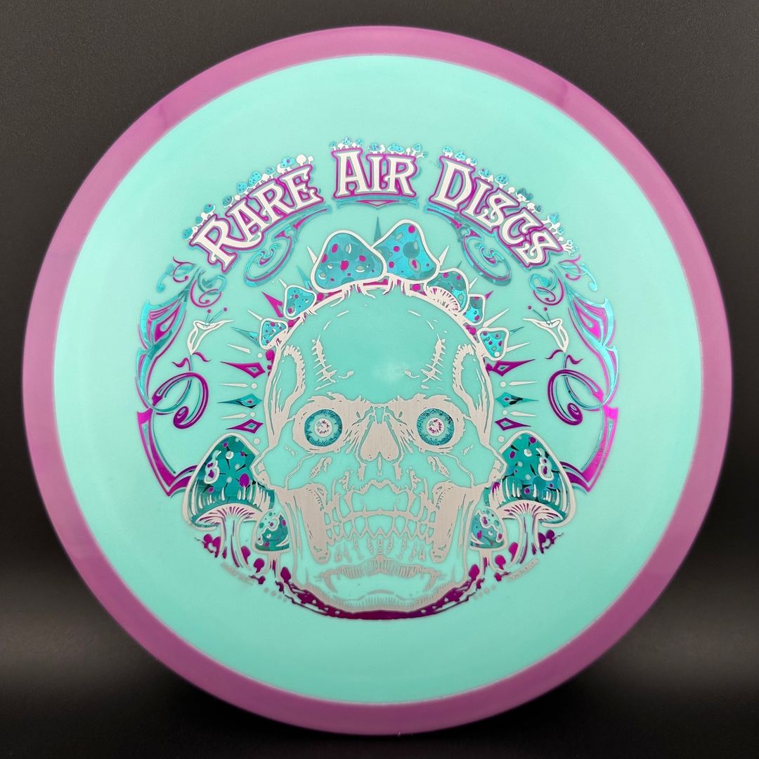Disc golf disc Fission Defy Crushin' Amanitas VIP 2.0 by Manny Trujillo, featuring vibrant design and premium plastic for optimal flight.