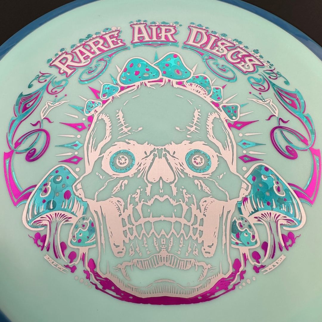 Disc golf disc Fission Defy Crushin' Amanitas VIP 2.0 by Manny Trujillo in Rare Air Discs branding, showing detailed design and vibrant colors.