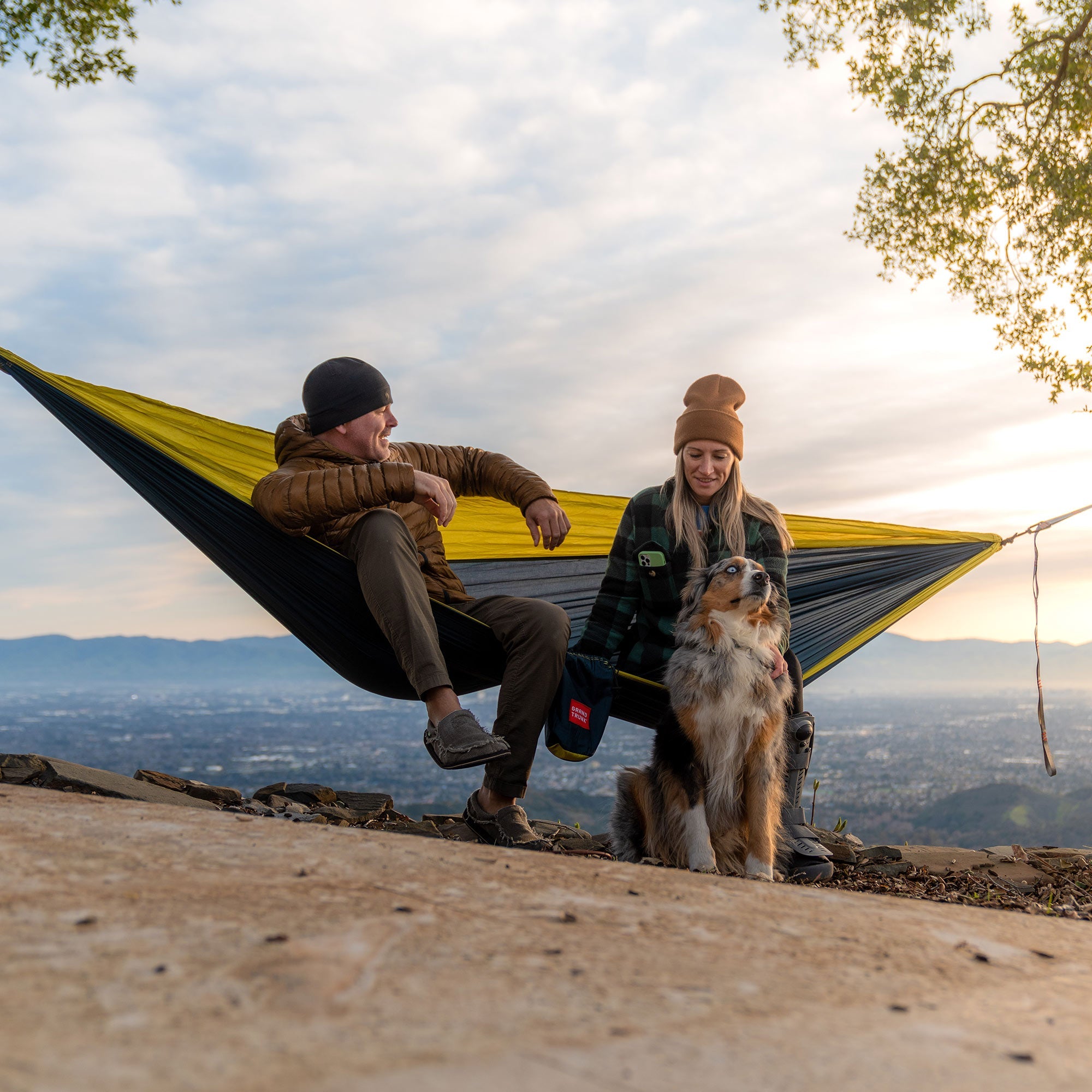 GrandTrunk Double Deluxe Hammock with straps, showing the wide, comfortable fabric and sturdy hanging straps in a relaxed outdoor setting.