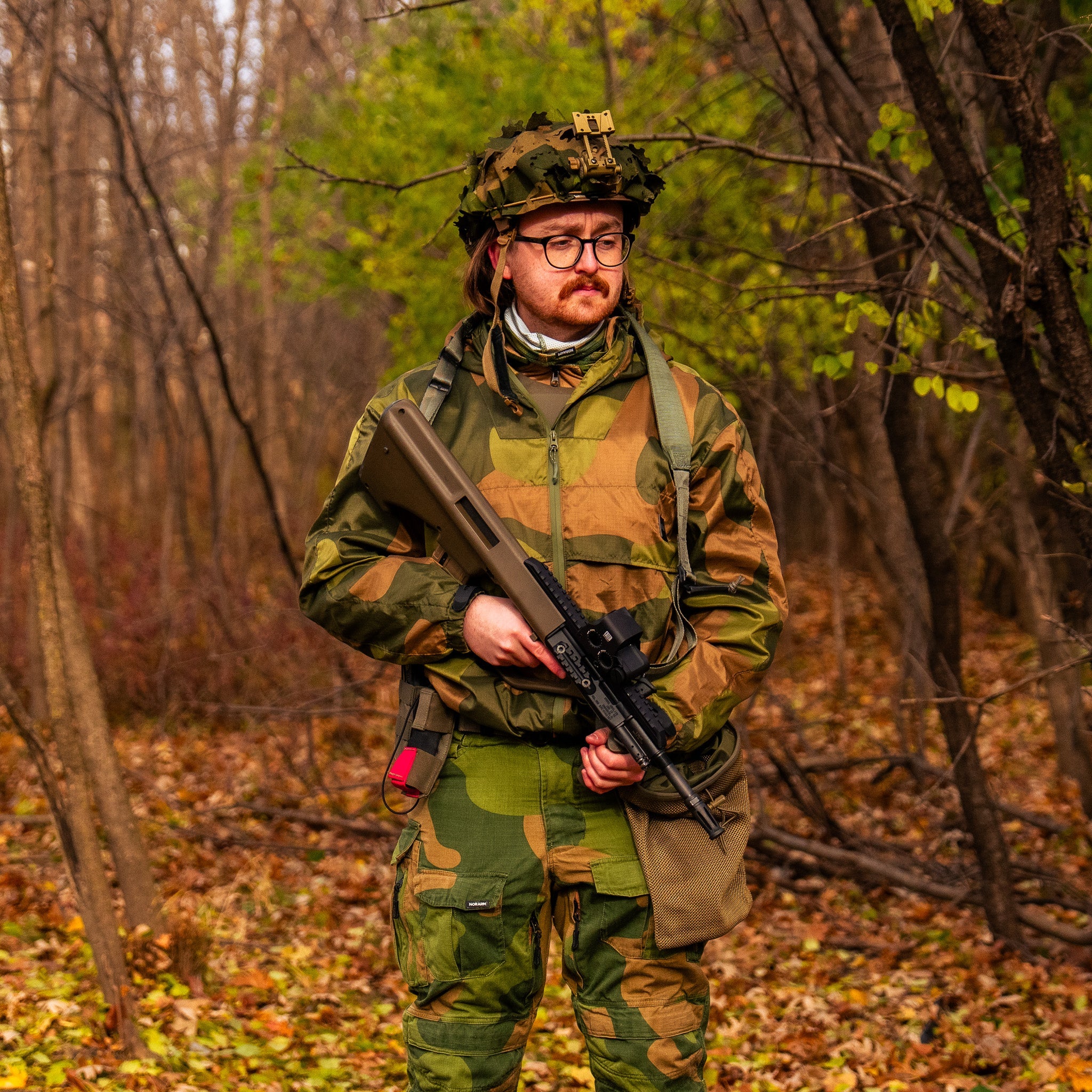 QILO x AP retro windbreaker in Norwegian Woodland camouflage by Americana Pipedream Apparel, shown in outdoor setting.