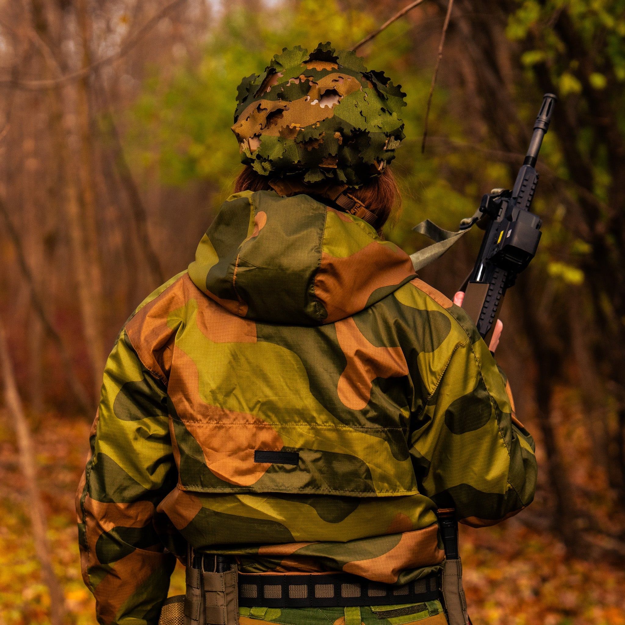 QILO x AP retro windbreaker in Norwegian Woodland camouflage by Americana Pipedream Apparel, shown with adjustable hood and front pockets.
