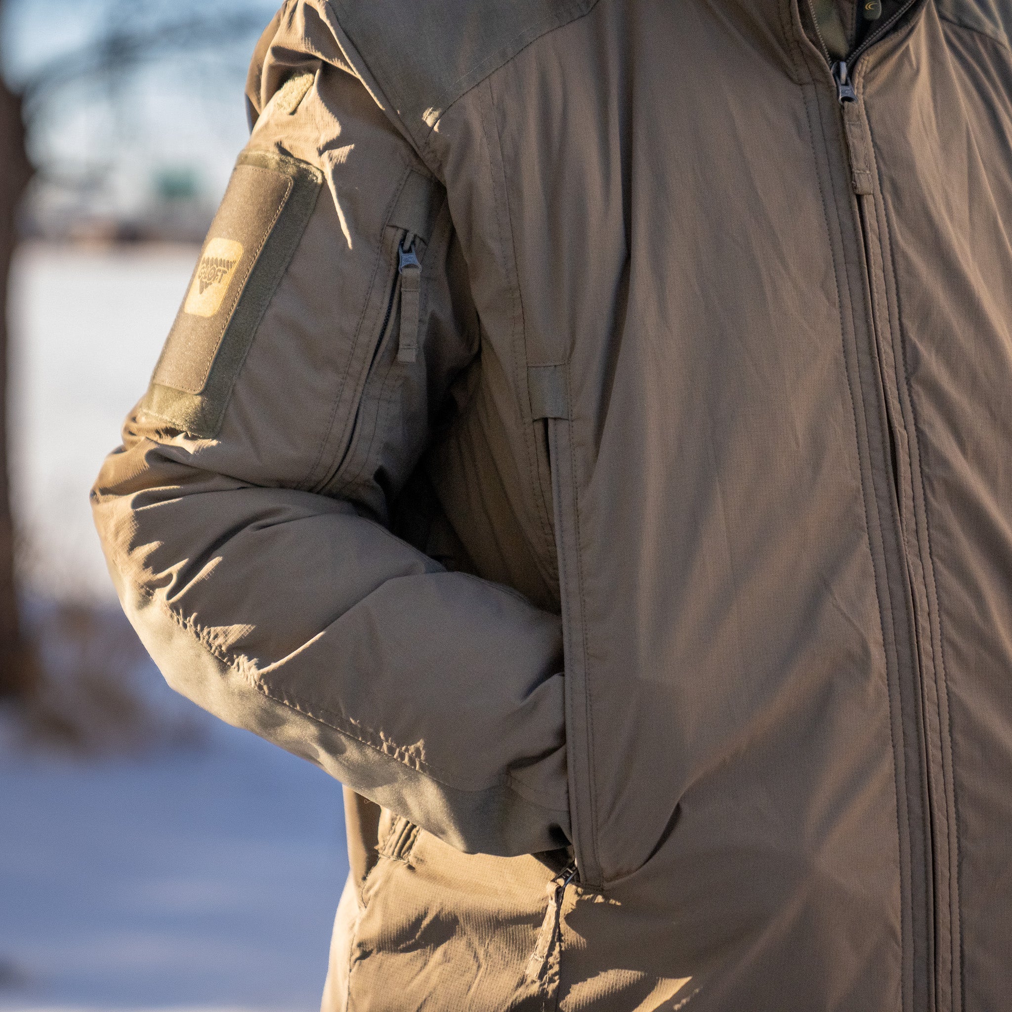 Carinthia HIG 4.0 jacket by Americana Pipedream Apparel, showcasing the insulated outdoor jacket with front zipper and adjustable hood.