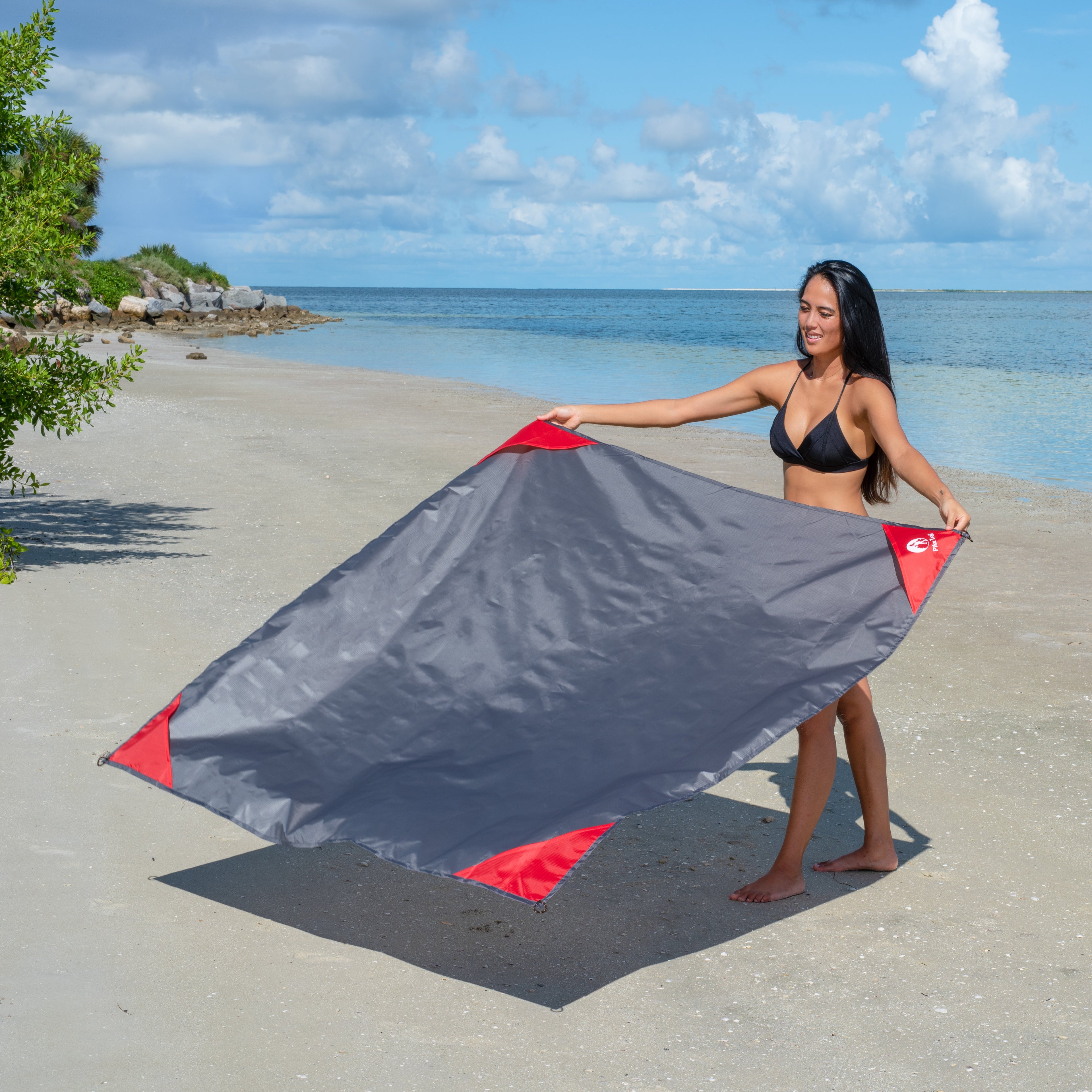 Pike Trail pocket blanket spread out on grass, compact and portable outdoor blanket for picnics and outdoor activities.