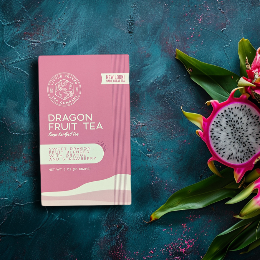 Herbal tea with vibrant pink and purple dragonfruit pieces in a clear glass cup, brewed by Little Prayer Tea Company.