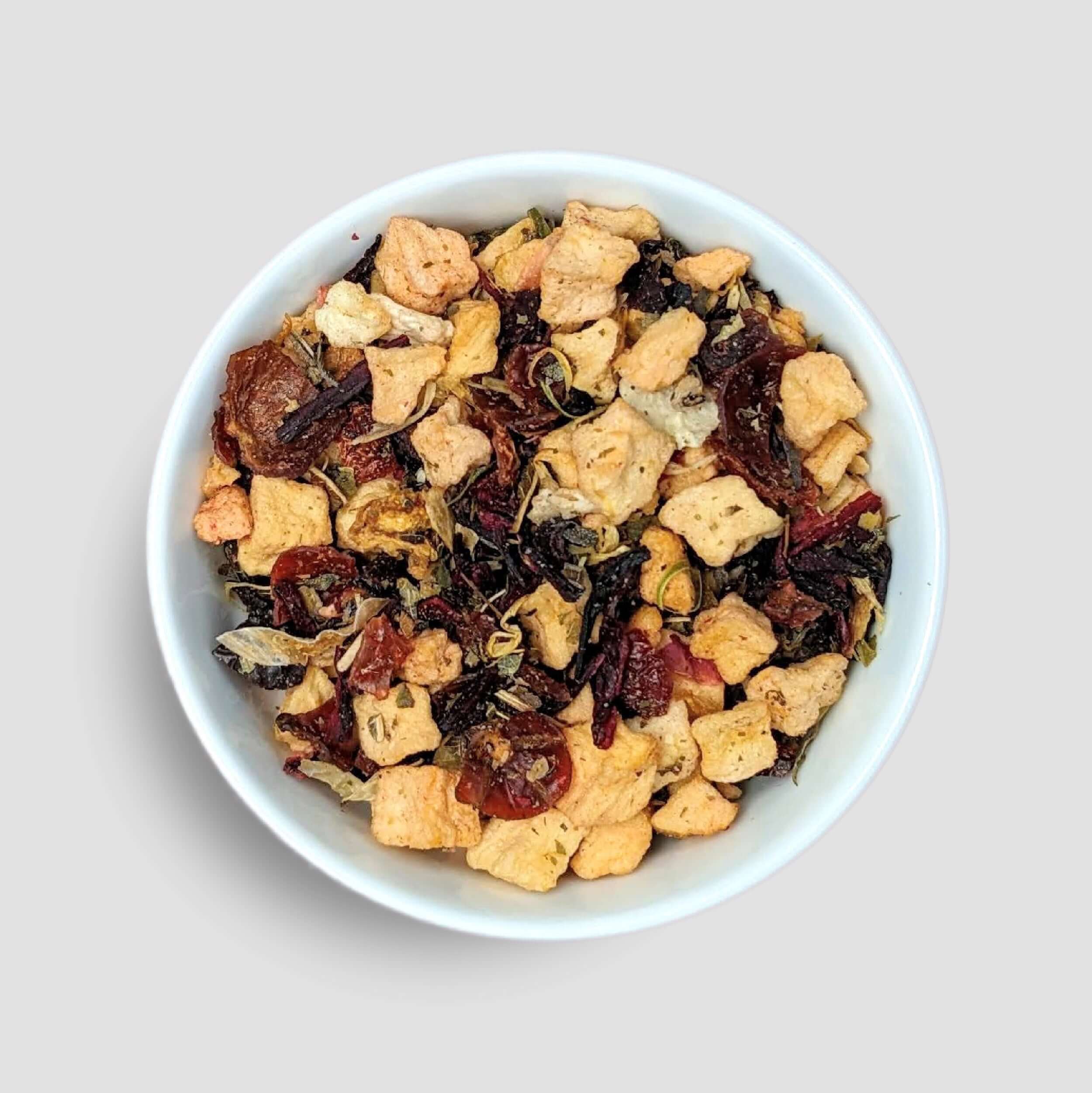 Herbal tea in a bowl featuring Dragonfruit Tea from Little Prayer Tea Company, vibrant pink and purple dragonfruit pieces submerged in tea.