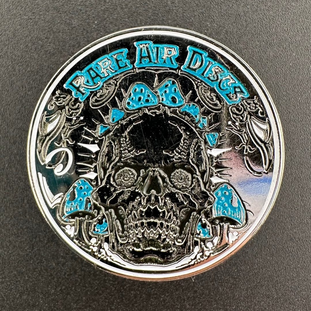 Crushin' Amanitas pin by Rare Air Discs featuring two color options, showcasing a detailed mushroom design on a metal accessory.