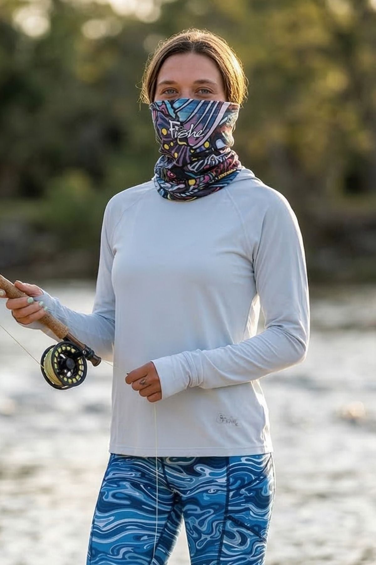 FisheWear Enchanted Grayling neck tube featuring a gray and blue aquatic pattern, worn around the neck for warmth and style.