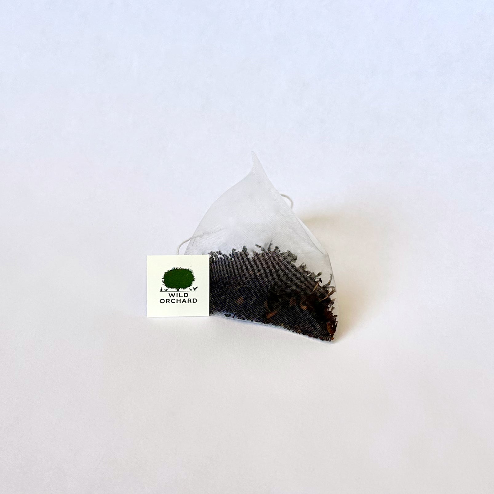 Organic black tea bag from Wild Orchard's Everyday Black collection, showing a neatly sealed black tea bag on a plain background.