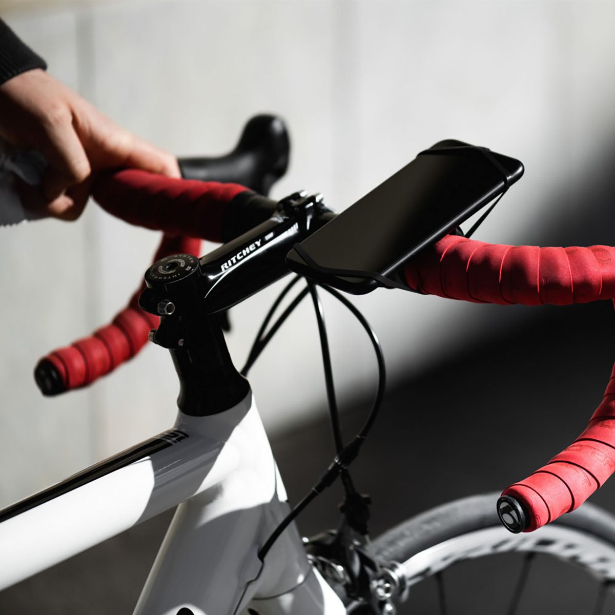 ZEITBIKE FINN universal bicycle phone mount in red attached to bike handlebar with phone secured in holder.