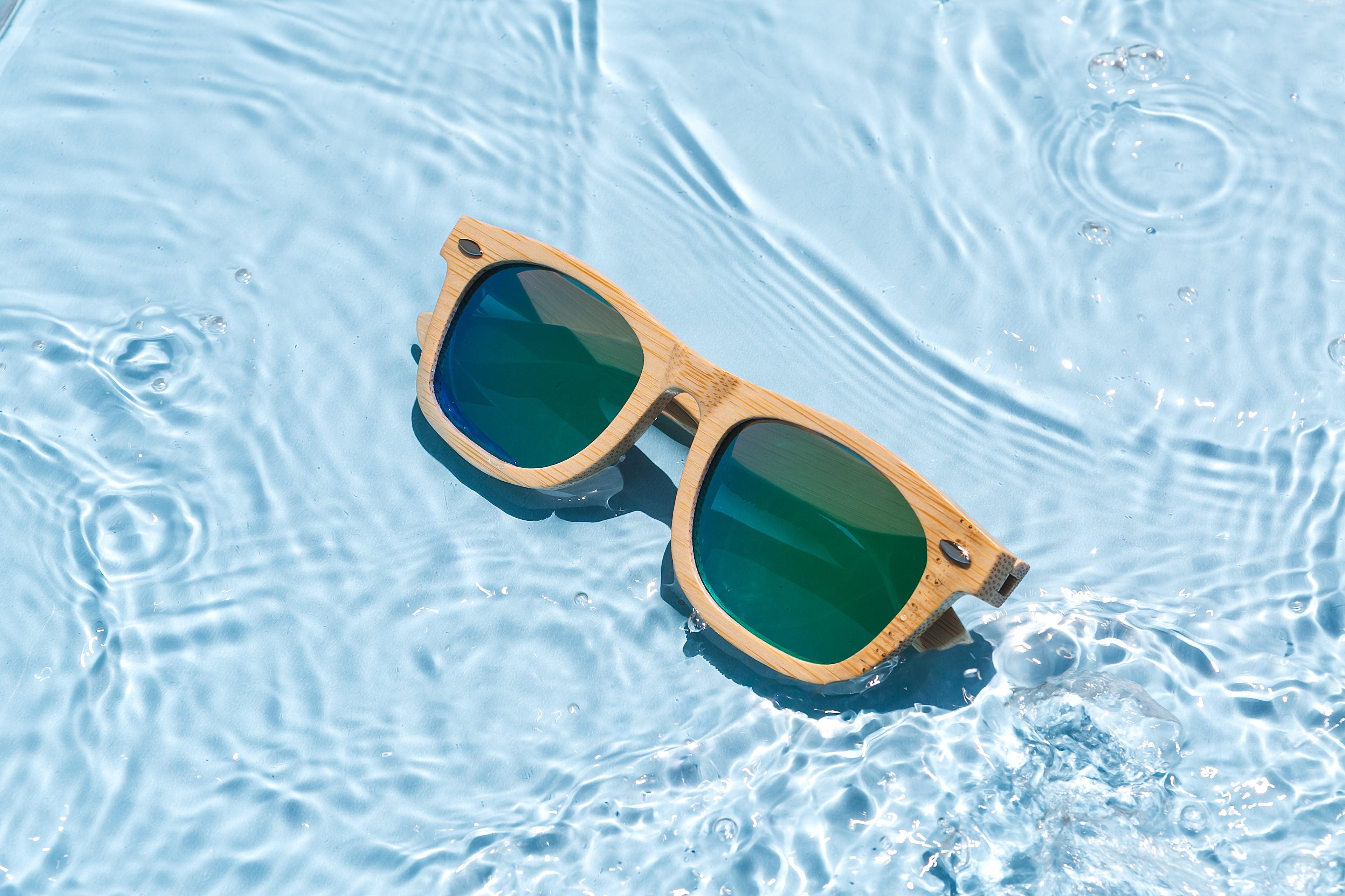 Bamboo floating sunglasses by Eastern Outer with round frames and polarized lenses, resting on a wooden surface.