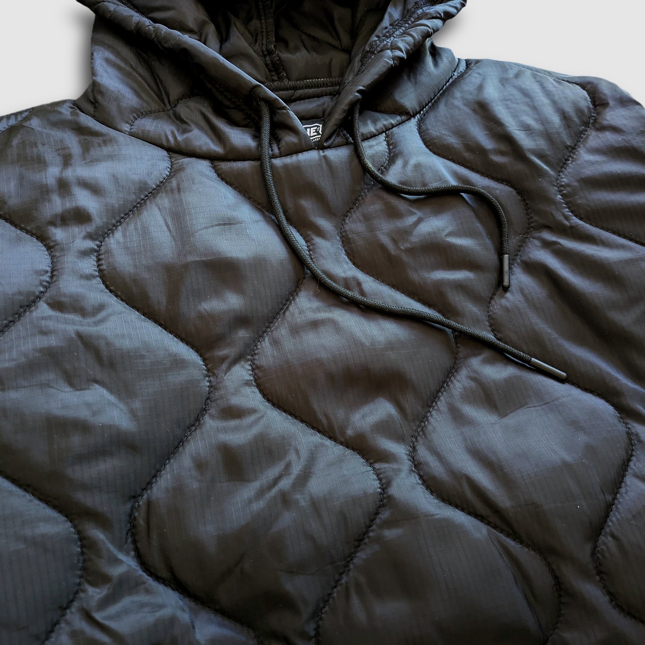 Black Sherwin Puff Hoodie by Faultline395, featuring a cozy puffer design and hood, ideal for casual streetwear style.