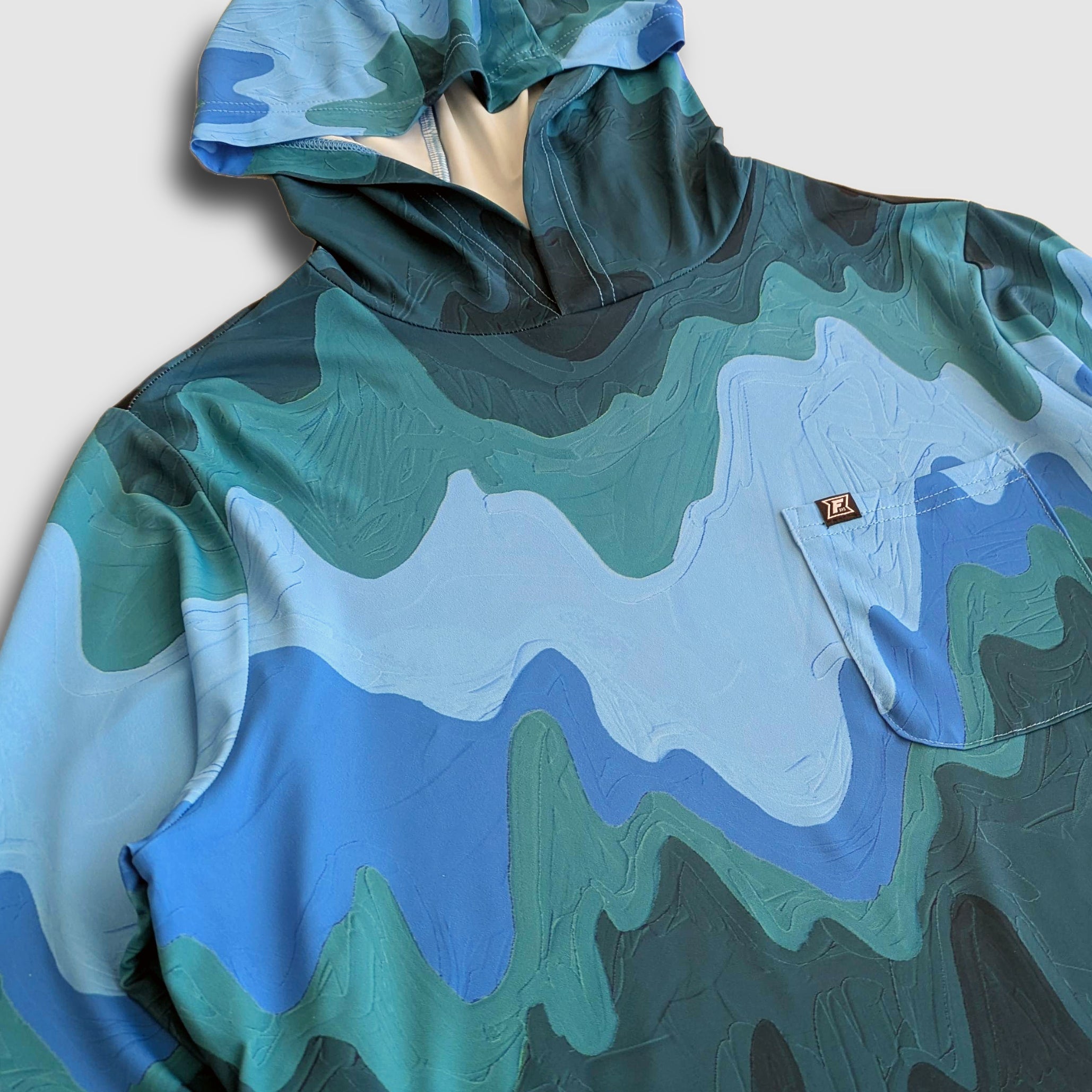Women's Faultline395 Carson Sun Hoodie with mountain wave pattern, lightweight fabric, and hood for sun protection.