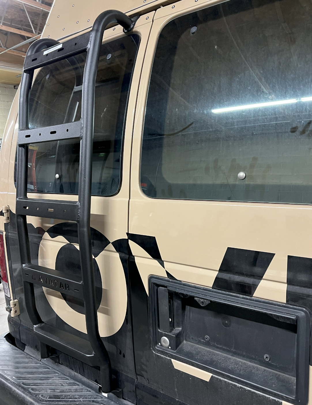 Ford E-Series rear ladder by Avatar Offroad mounted on the vehicle's back for easy access to the roof or cargo area.
