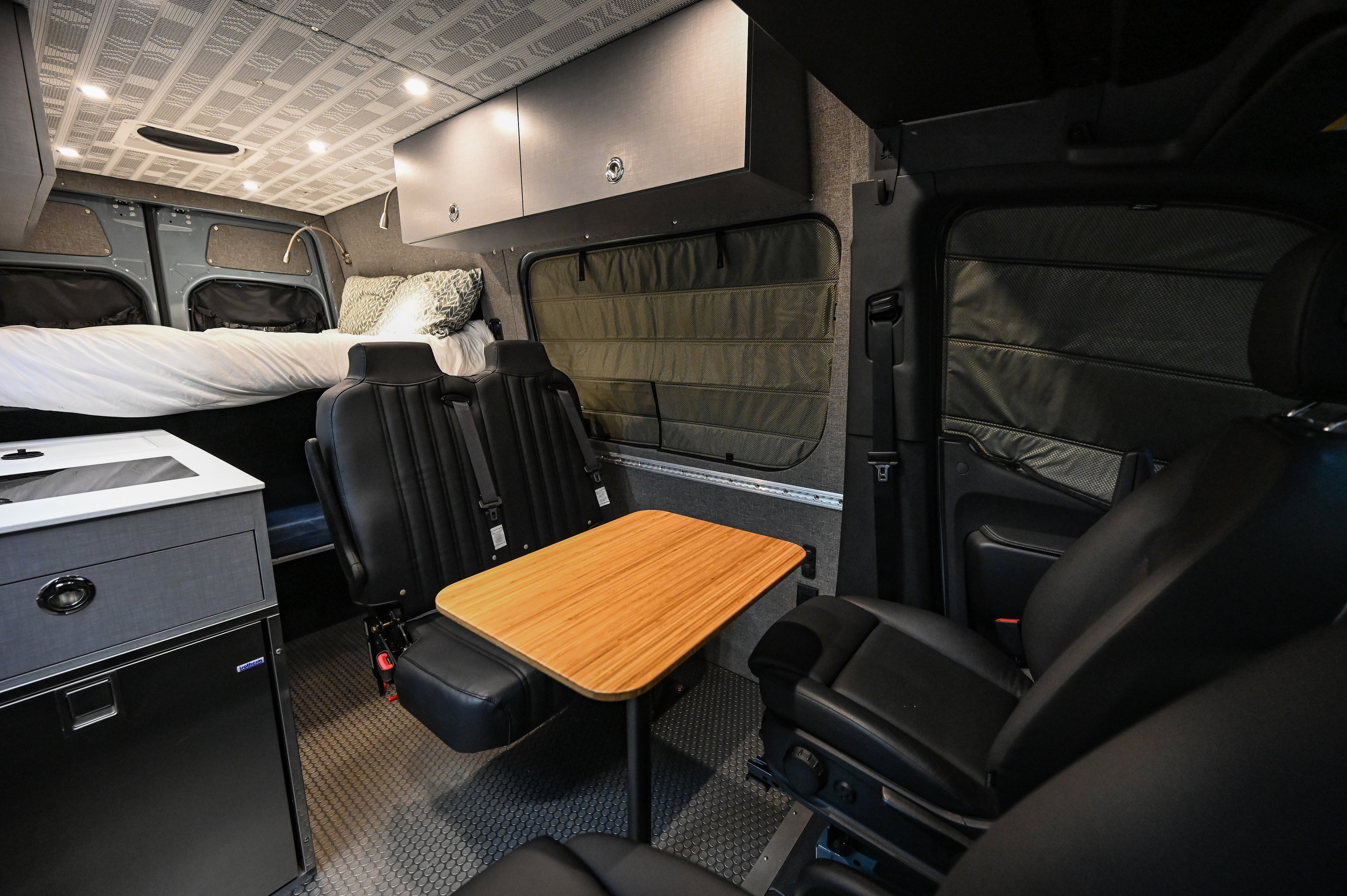 Alpine Van Works Hide N' Go Seat, a versatile seating solution with a padded cushion and compact design for vehicle use.