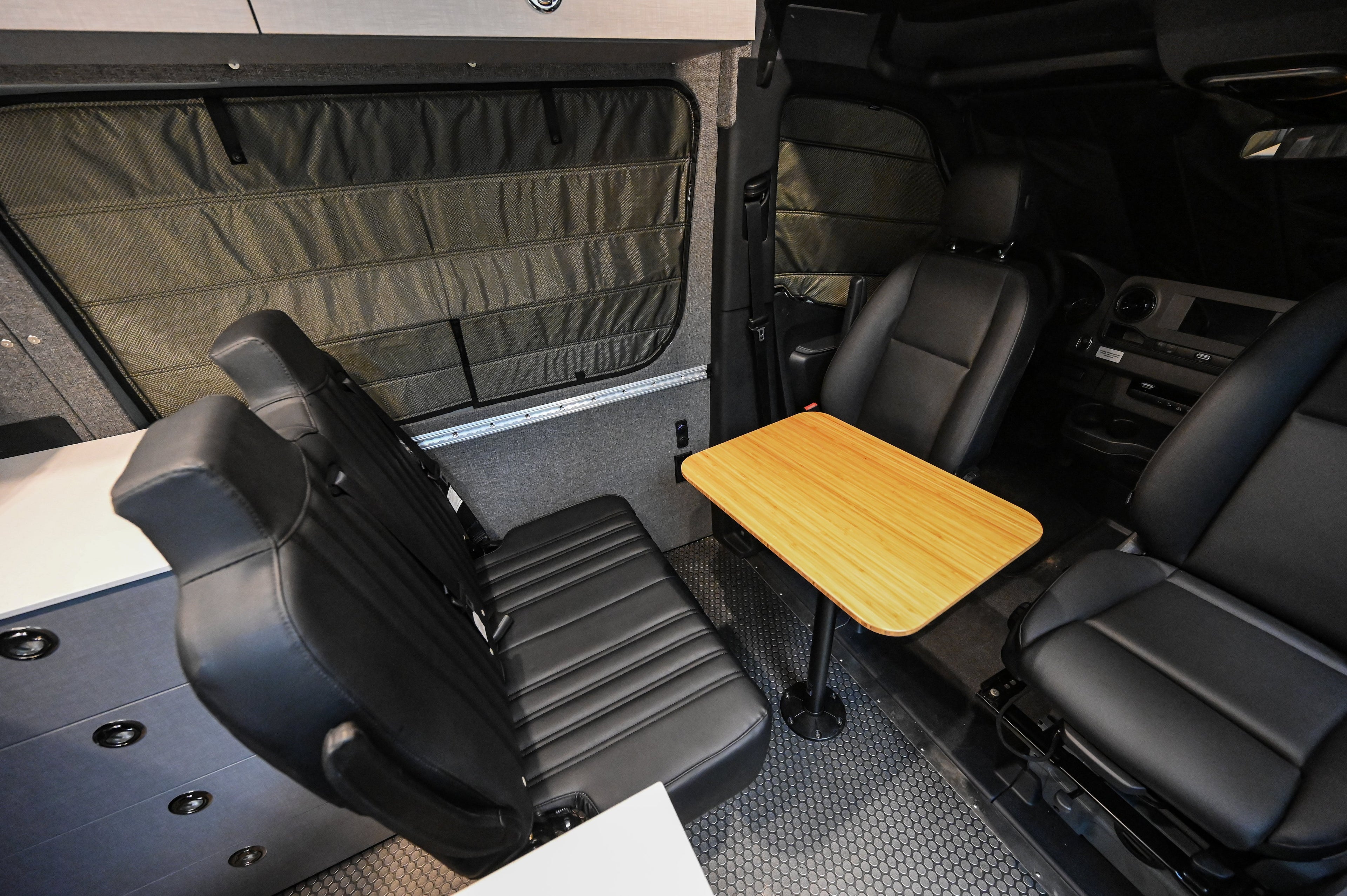 Alpine Van Works Hide N' Go Seat, versatile seating solution with foldable design, shown in a vehicle interior.