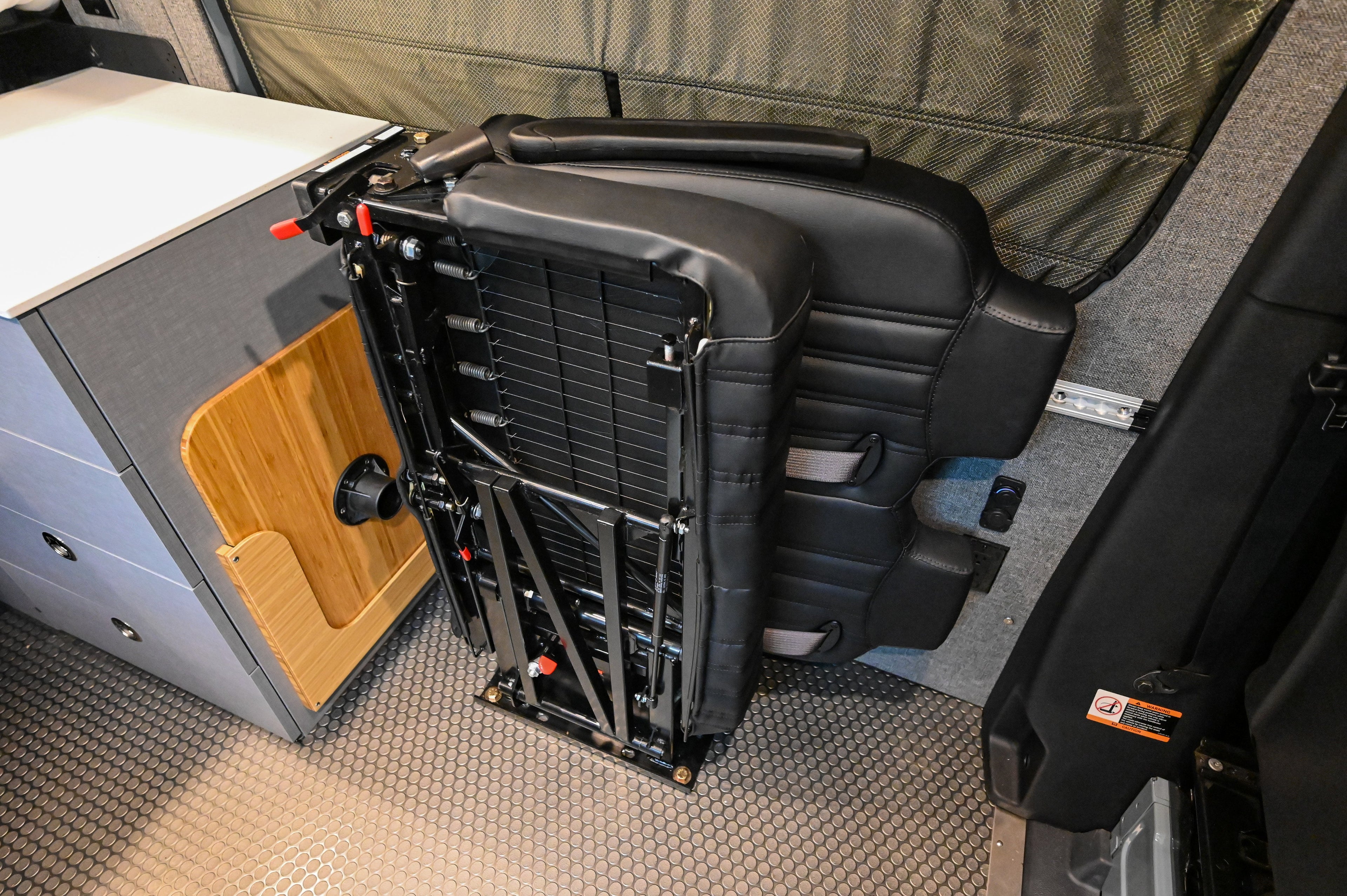 Alpine Van Works Hide N' Go Seat in seating configuration, showcasing its compact and versatile design for vehicle interiors.