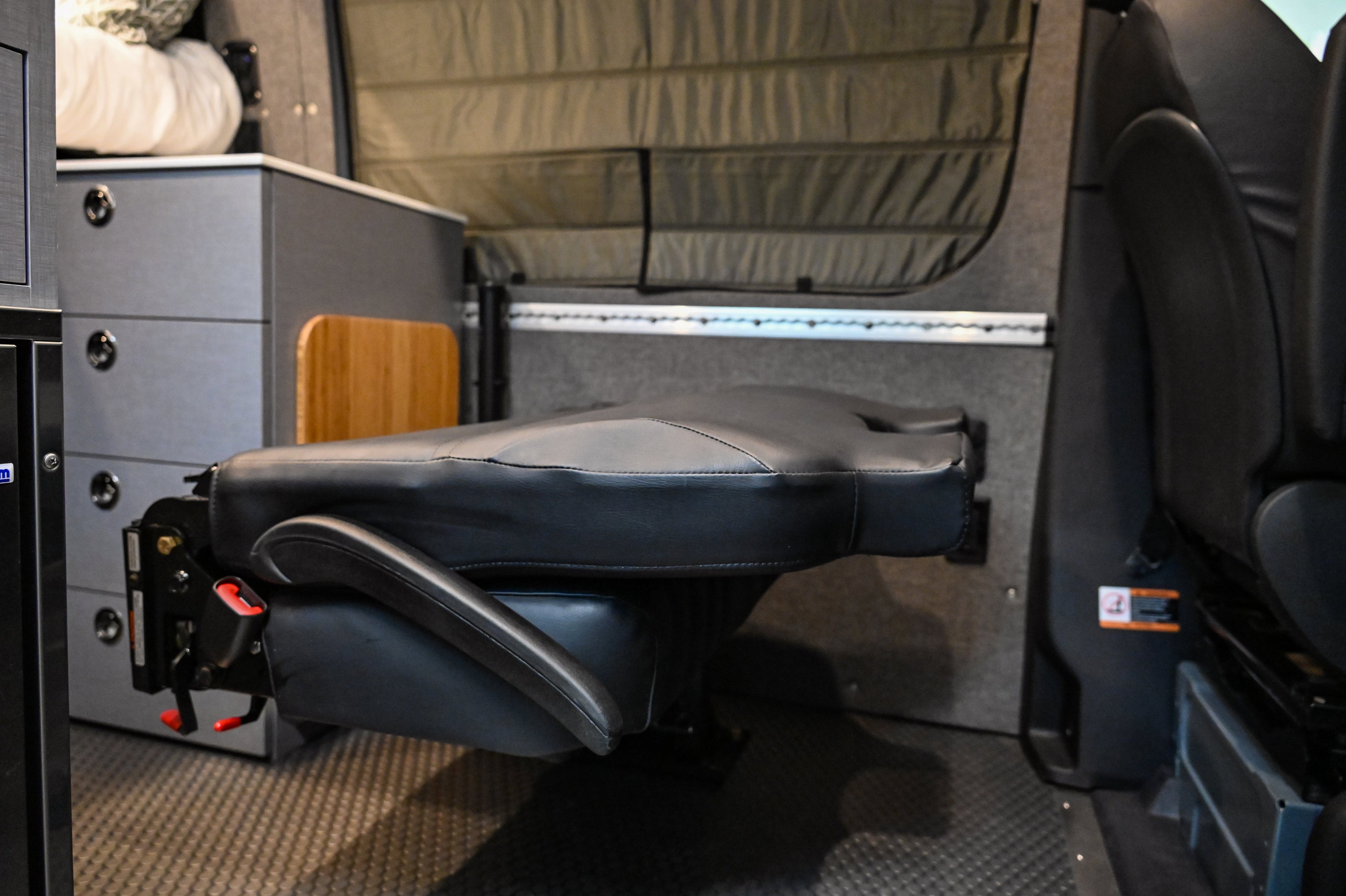 Alpine Van Works Hide N' Go Seat, versatile seating solution, shown in a compact, foldable position for easy storage.