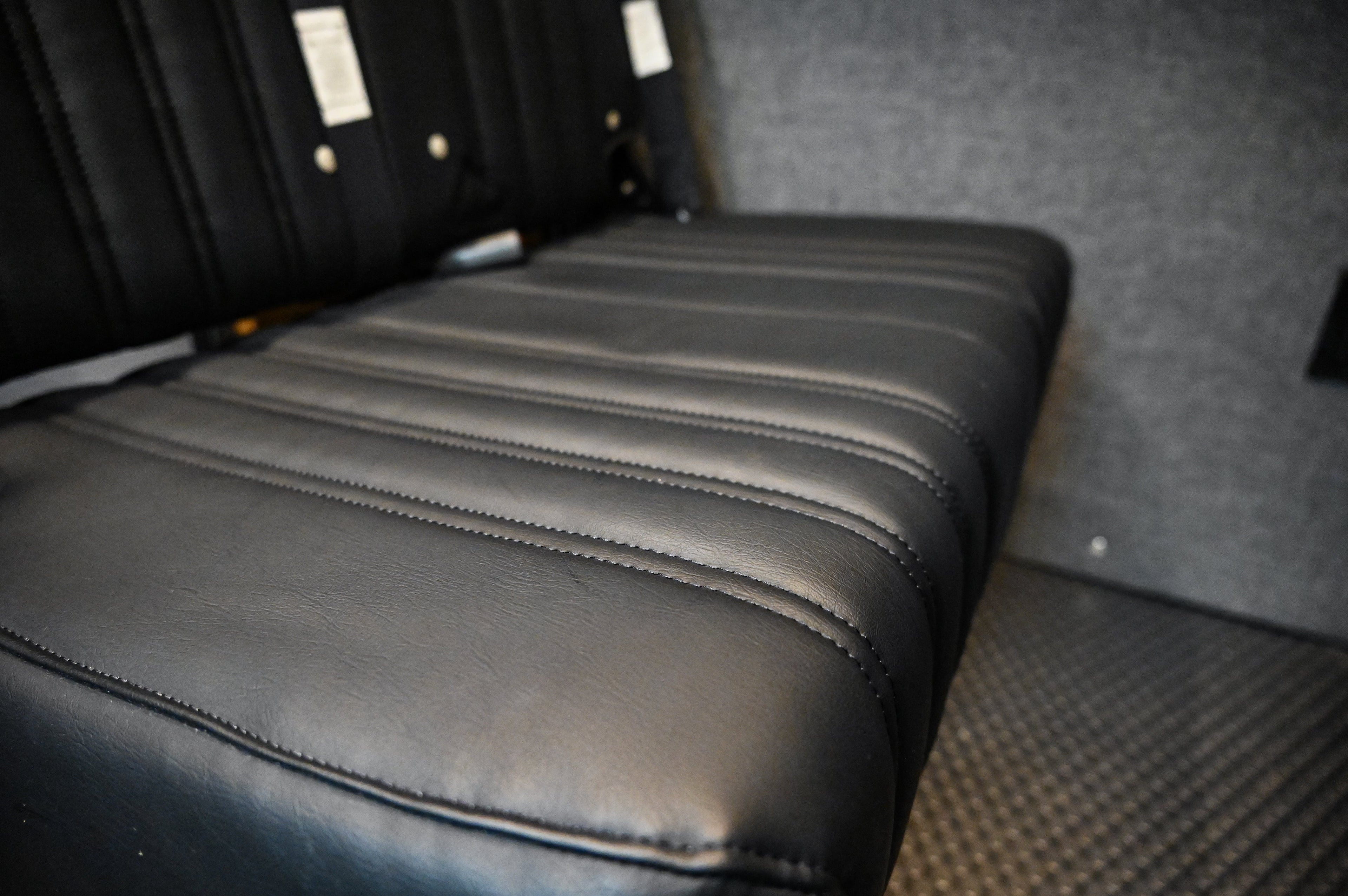 Alpine Van Works Hide N' Go Seat, a versatile seating solution, shown in a compact, foldable design for vehicle interiors.