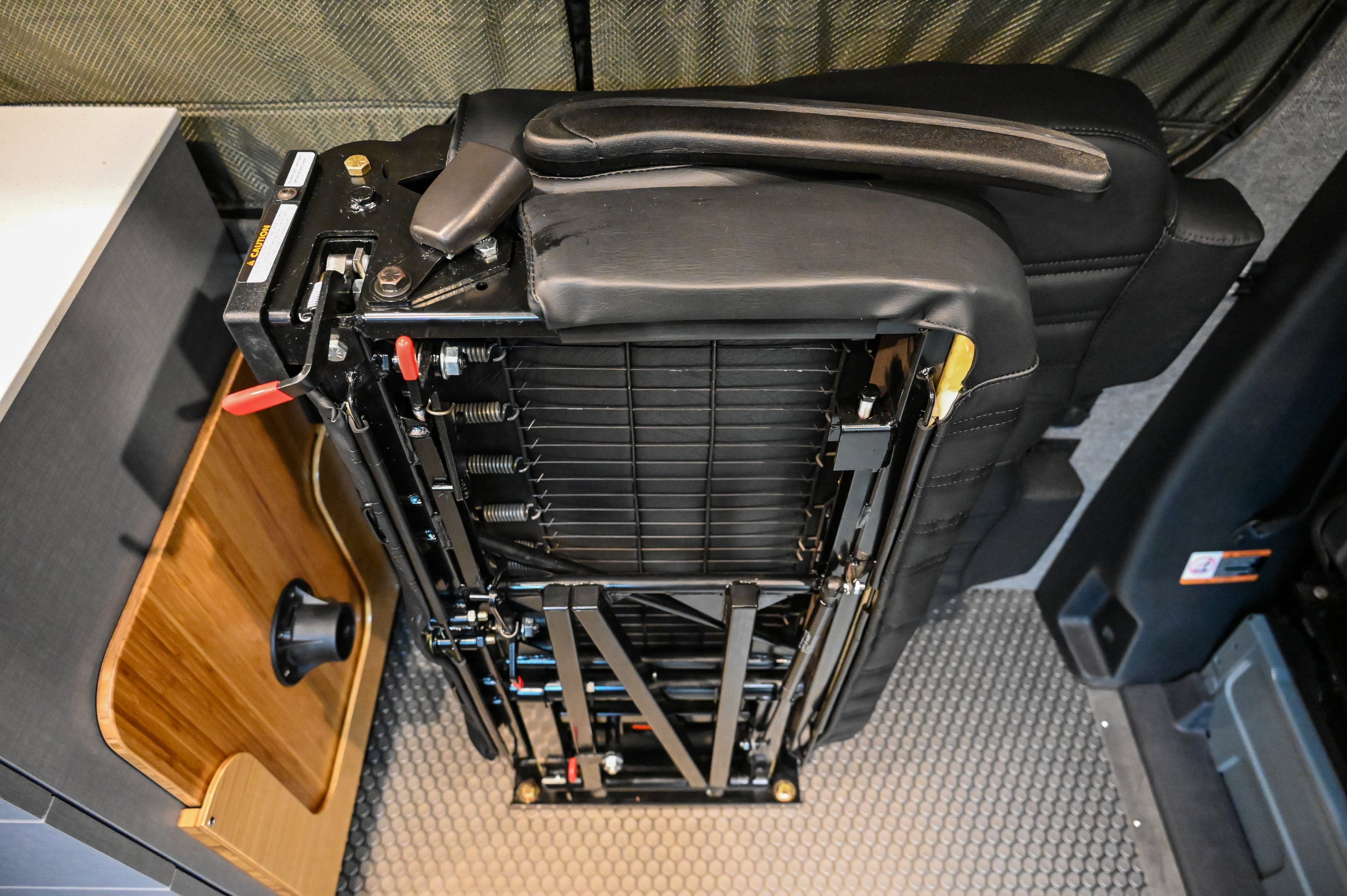 Alpine Van Works Hide N' Go Seat, versatile seating solution with foldable design for van interiors.