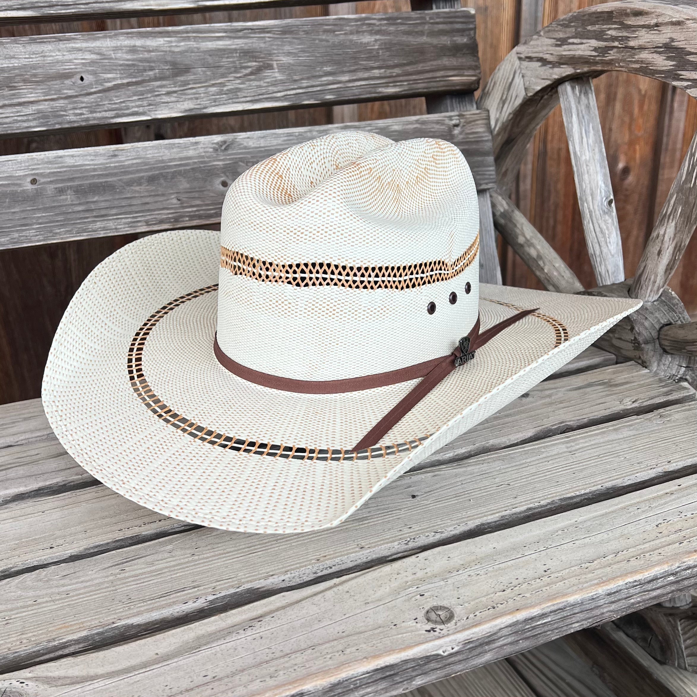 Ariat two-toned straw hat with a wide brim, showcasing a stylish design perfect for sunny outdoor activities.