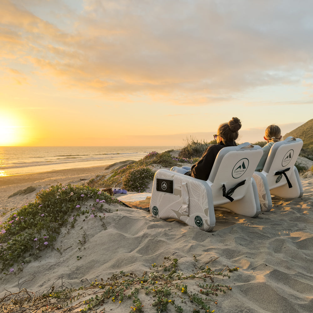 Inflatable captain's chair by Further Customs, featuring a vibrant sunset design, perfect for beach relaxation.