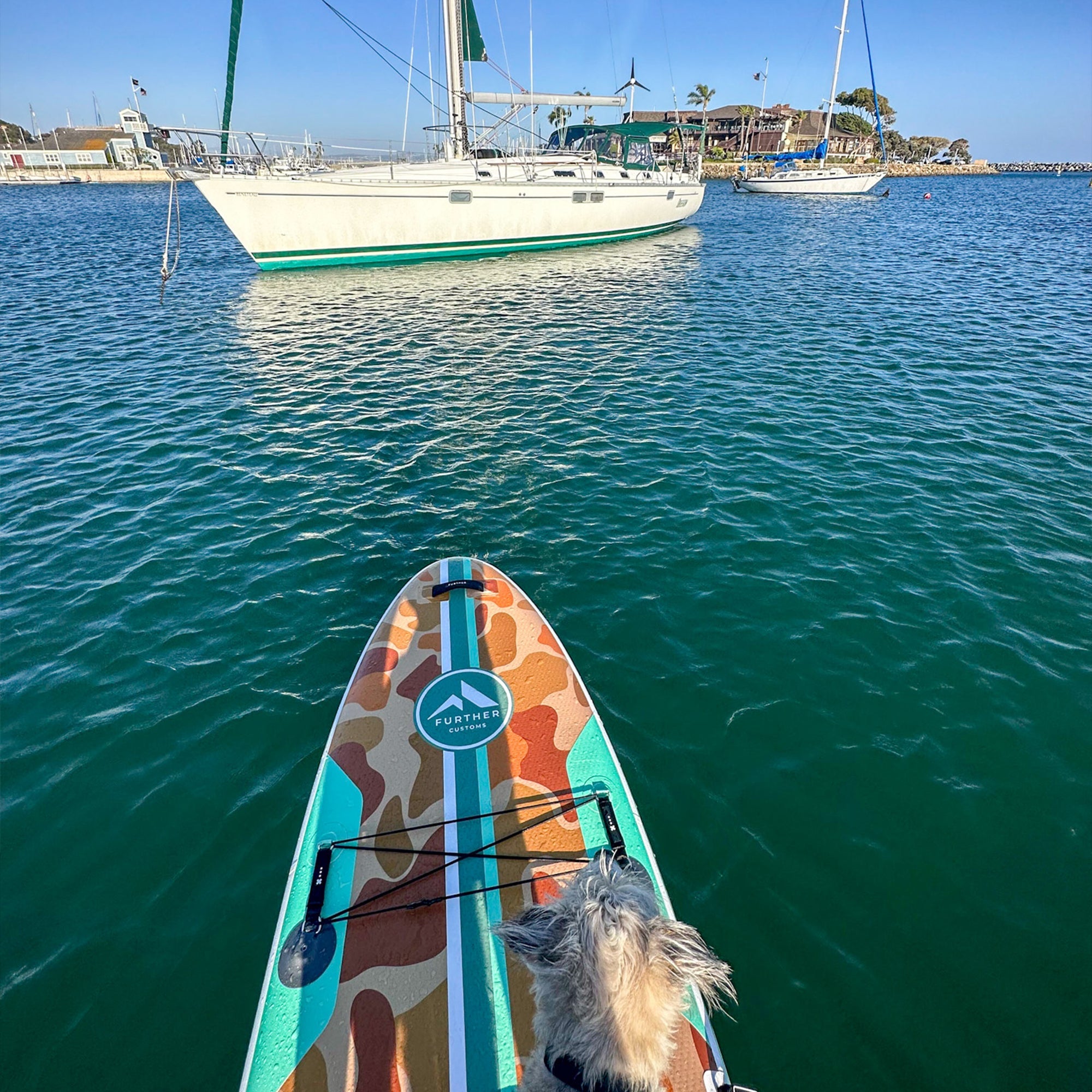 11'0" Tamarack Sage paddleboard by Further Customs, shown in Dana Point Harbor with a sleek design and sturdy construction.