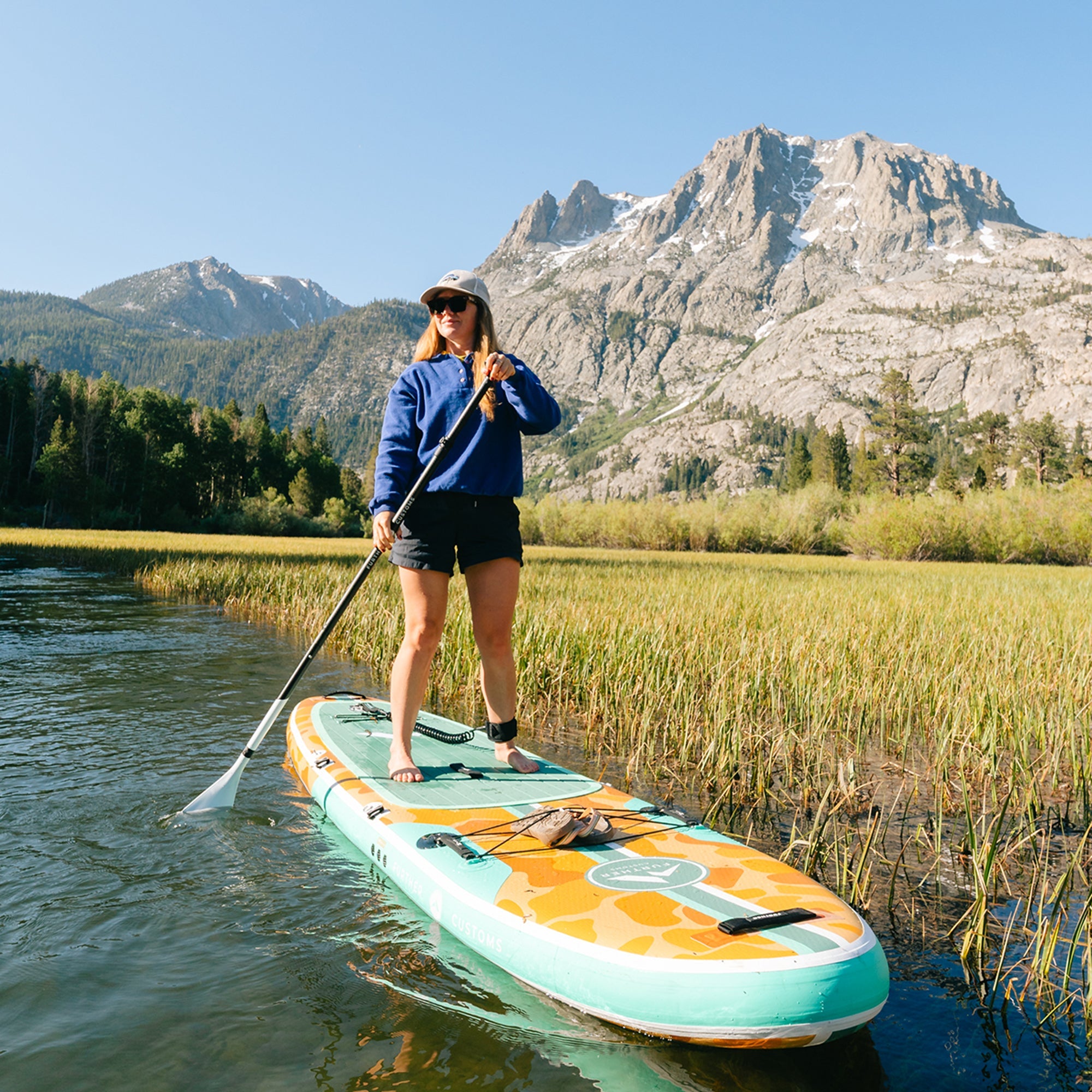Further Customs 11'0 Tamarack Sage inflatable paddleboard with stand-up paddleboard kit on mountain lake, ready for water adventure.