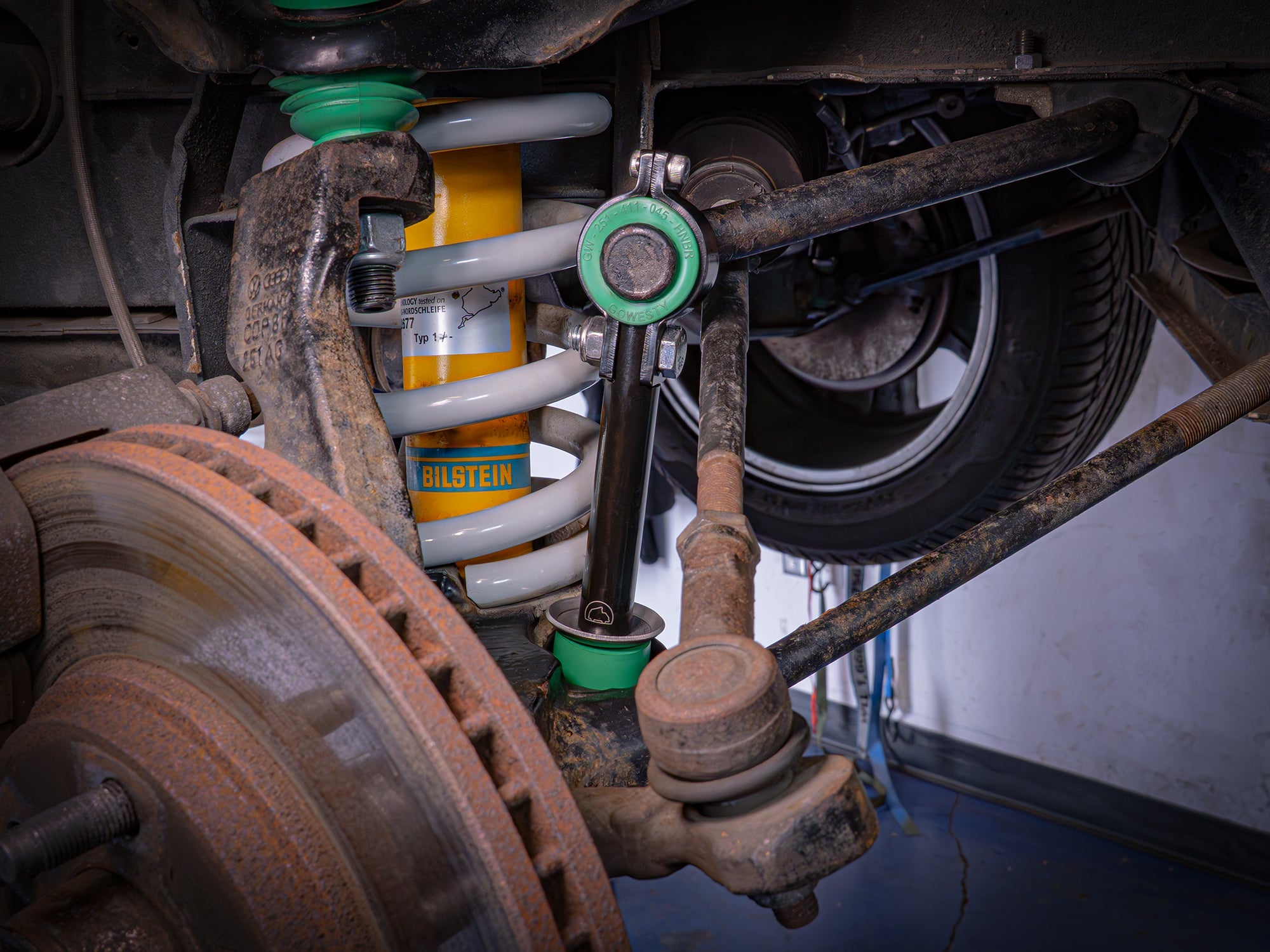 GoWesty front sway bar bushing bundle installed on a Vanagon, showing the rubber bushings and metal brackets in a vehicle suspension setup.