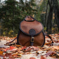 Backcountry Sportsman Bison Leather Lady Slipper Pack with outdoor gear, featuring a rugged, tan leather design and adjustable straps.