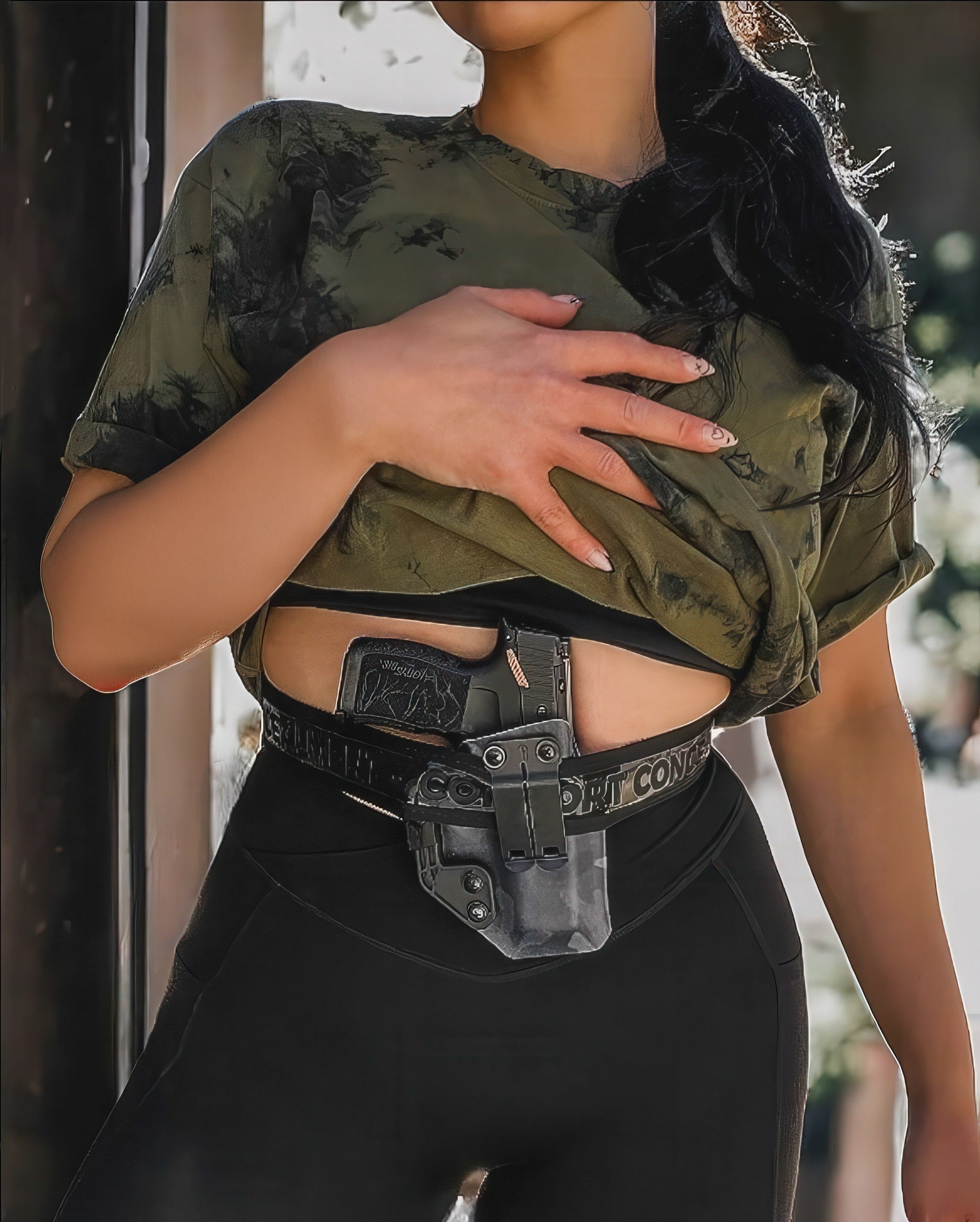 Edited image of a woman wearing the Comfort Concealment BLACKOUT 2.0™ concealed carry belt, showcasing its discreet design and adjustable fit.