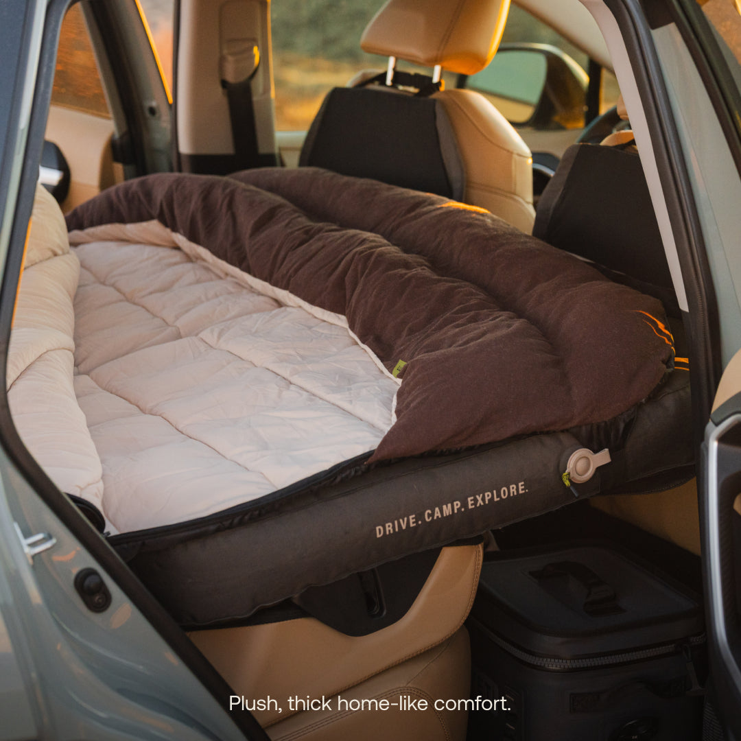 Luno® fitted sleeping bag comforter in a cozy outdoor setting, showcasing its soft fabric and compact design.