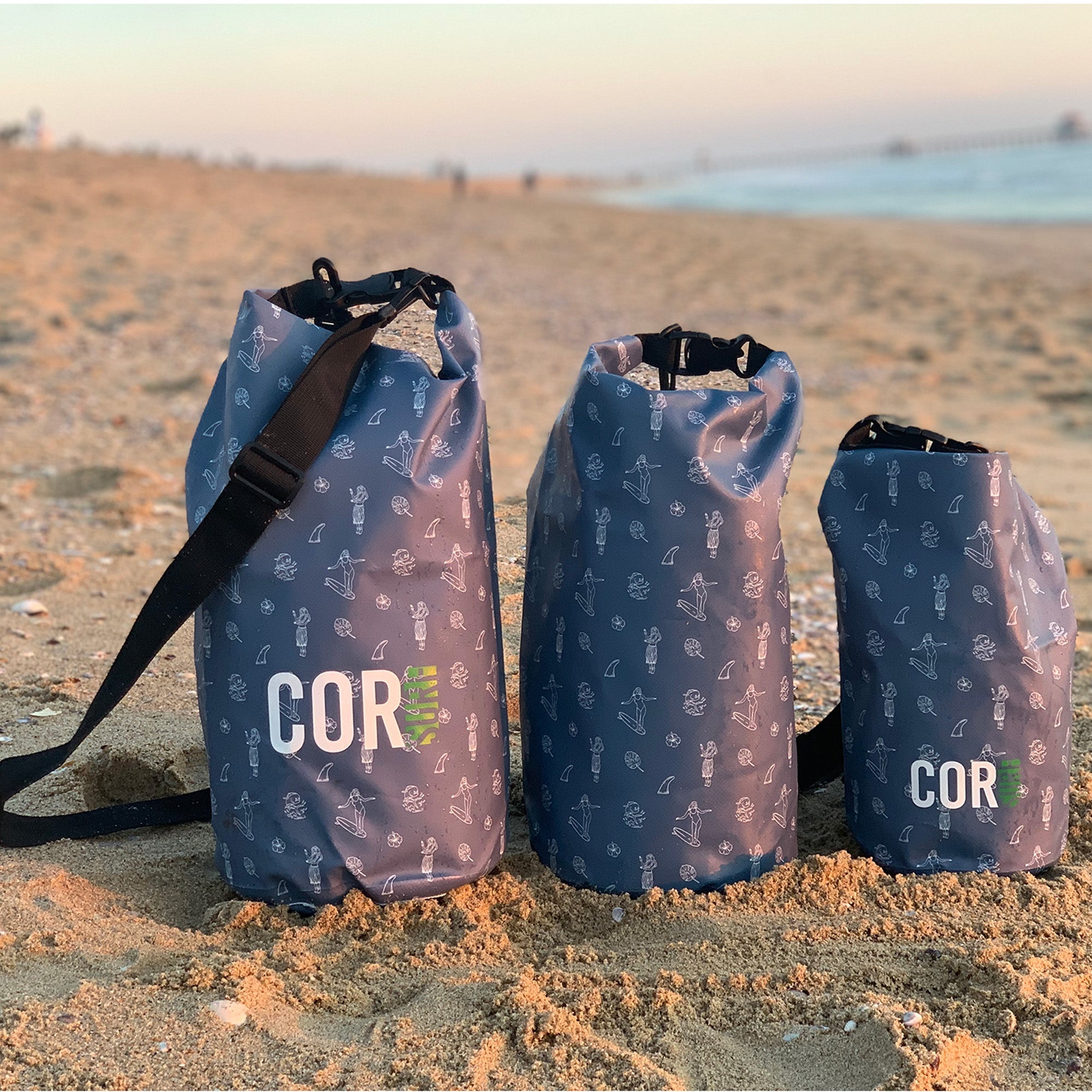 Cor Surf Hawaiian print dry bags in 3L, 5L, 10L, 15L, and 3-pack, shown on the beach for waterproof outdoor gear.