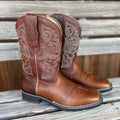 A pair of Delilah Stretchfit women's western boots by Ariat with tan leather and decorative stitching, standing on a wooden floor.