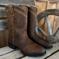 A pair of brown Ariat Heritage Roper women's Western boots with classic stitching and Western-style design.