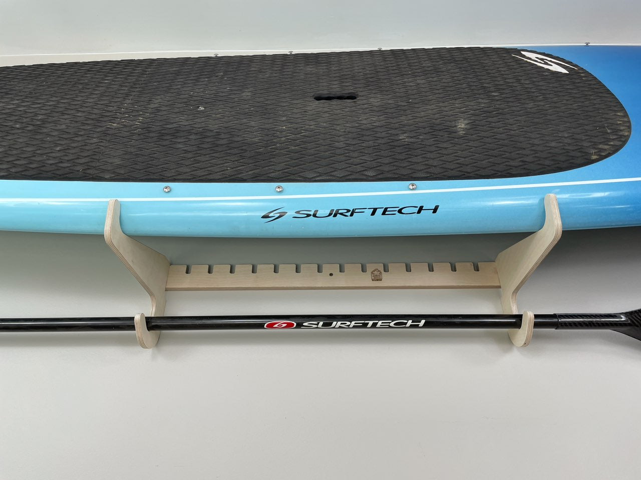 Rado Racks THE PORT SUP paddle board rack mounted on wall, holding multiple paddle boards for organized storage.