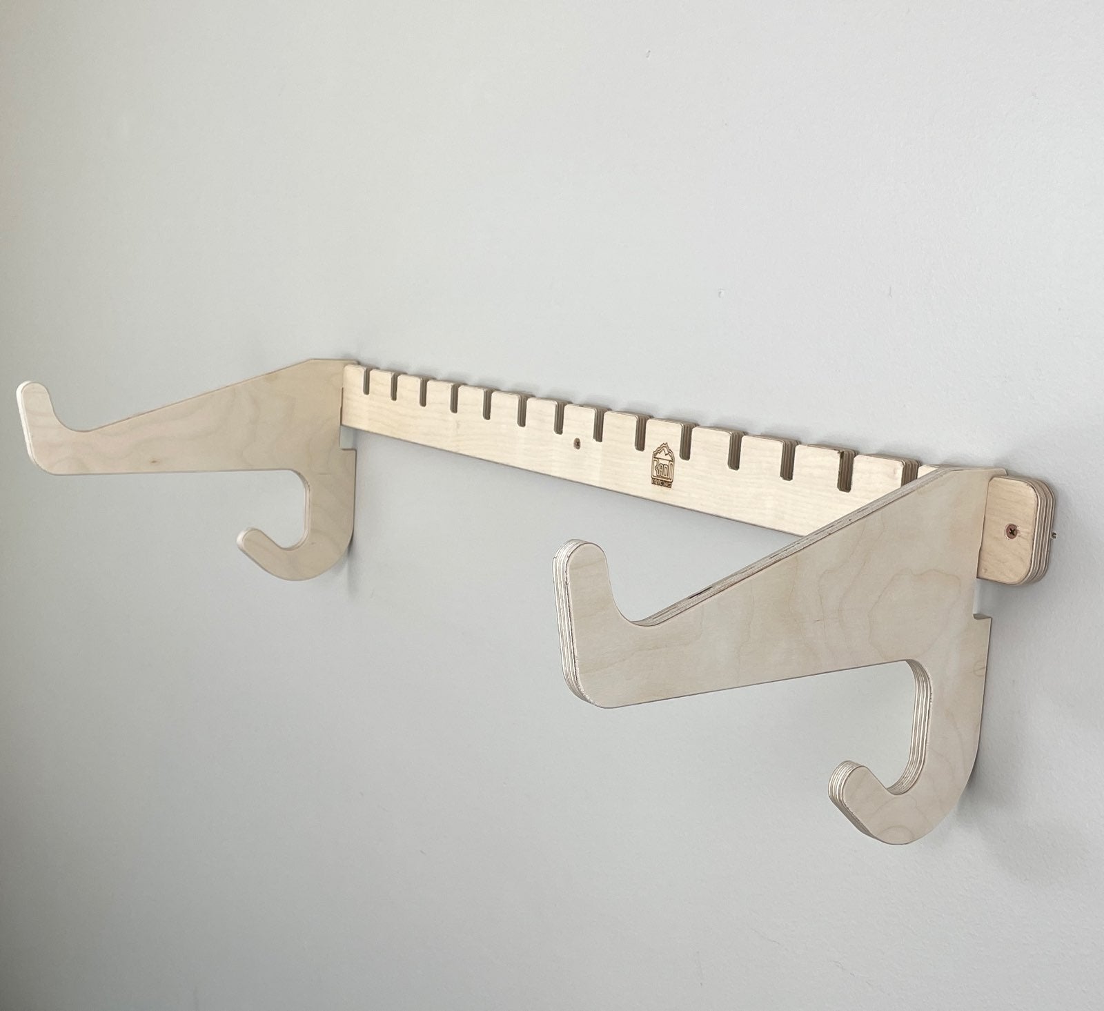Rado Racks THE PORT SUP paddle board rack mounted on a wall, holding a paddleboard securely in a home storage setting.
