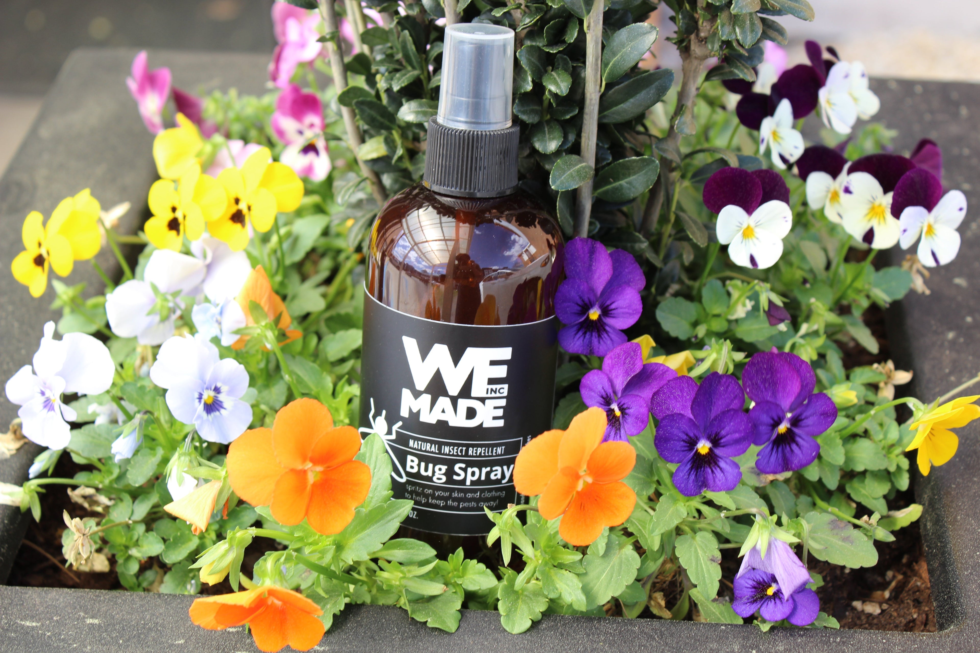 Bottle of WE Made natural insect repellent bug spray with outdoor-friendly spray nozzle, designed to repel insects effectively.