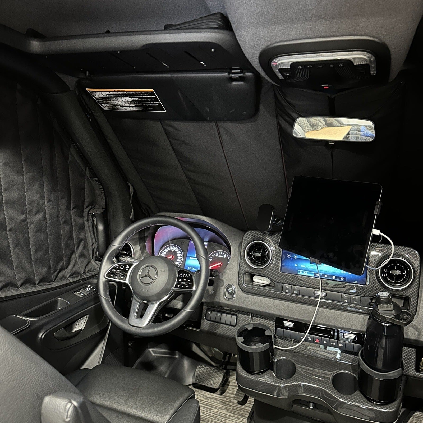 Canyon Adventure Vans CLIMA-SHADE™ insulated front windshield cover on a vehicle, designed to block heat and protect the windshield.