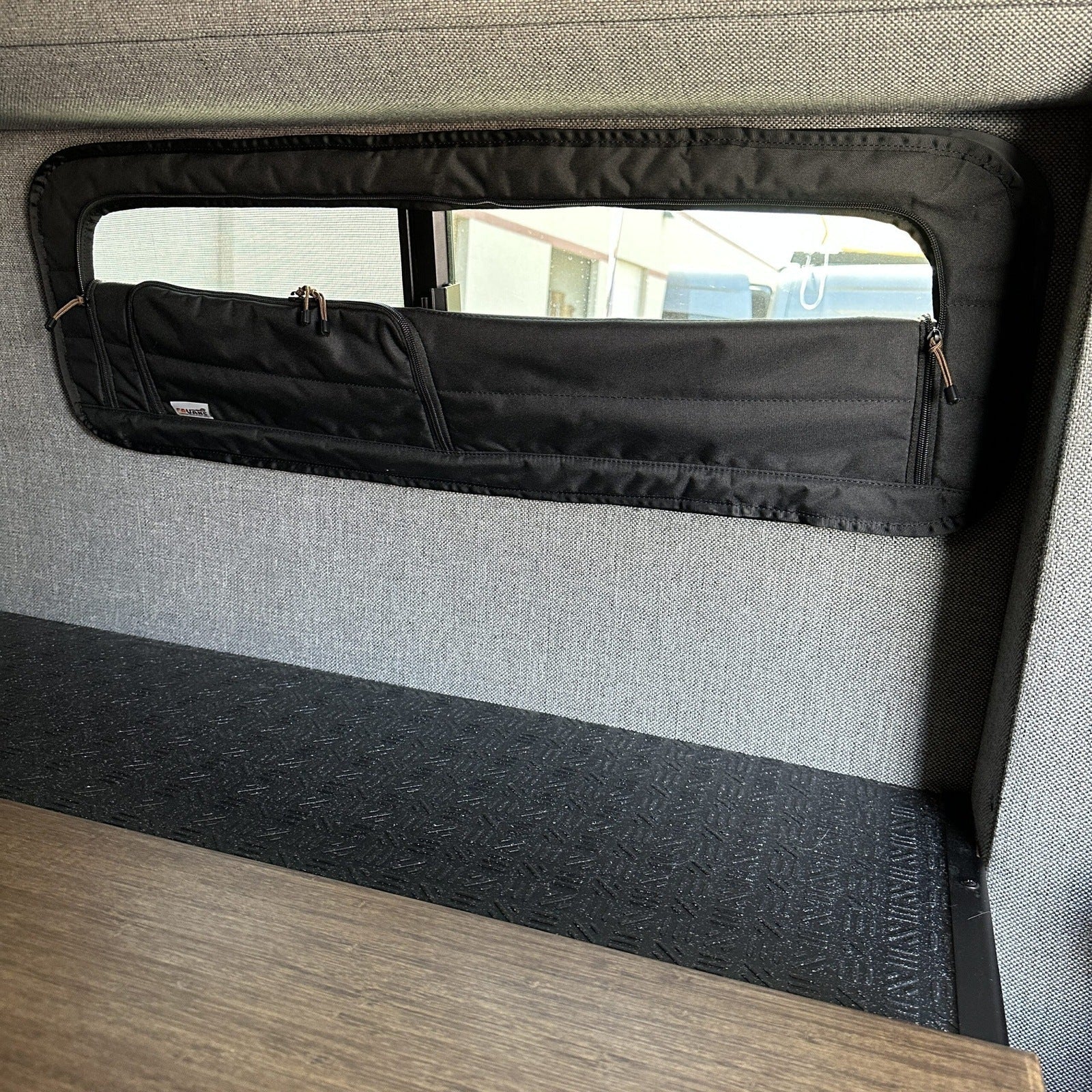 Canyon Adventure Vans CLIMA-SHADE™ insulated bunk window cover installed on a camper van window for insulation and privacy.