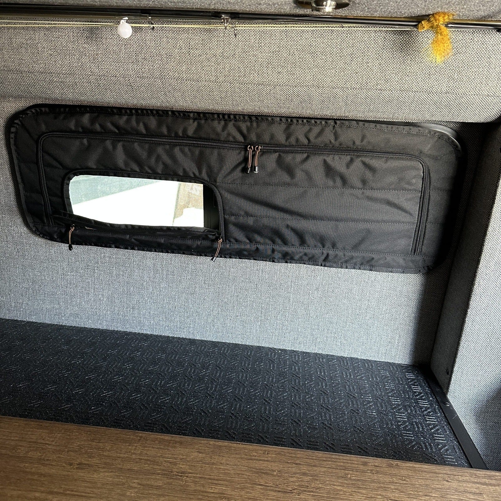 Canyon Adventure Vans CLIMA-SHADE™ insulated bunk window cover, CAV branded, installed on van window for insulation and privacy