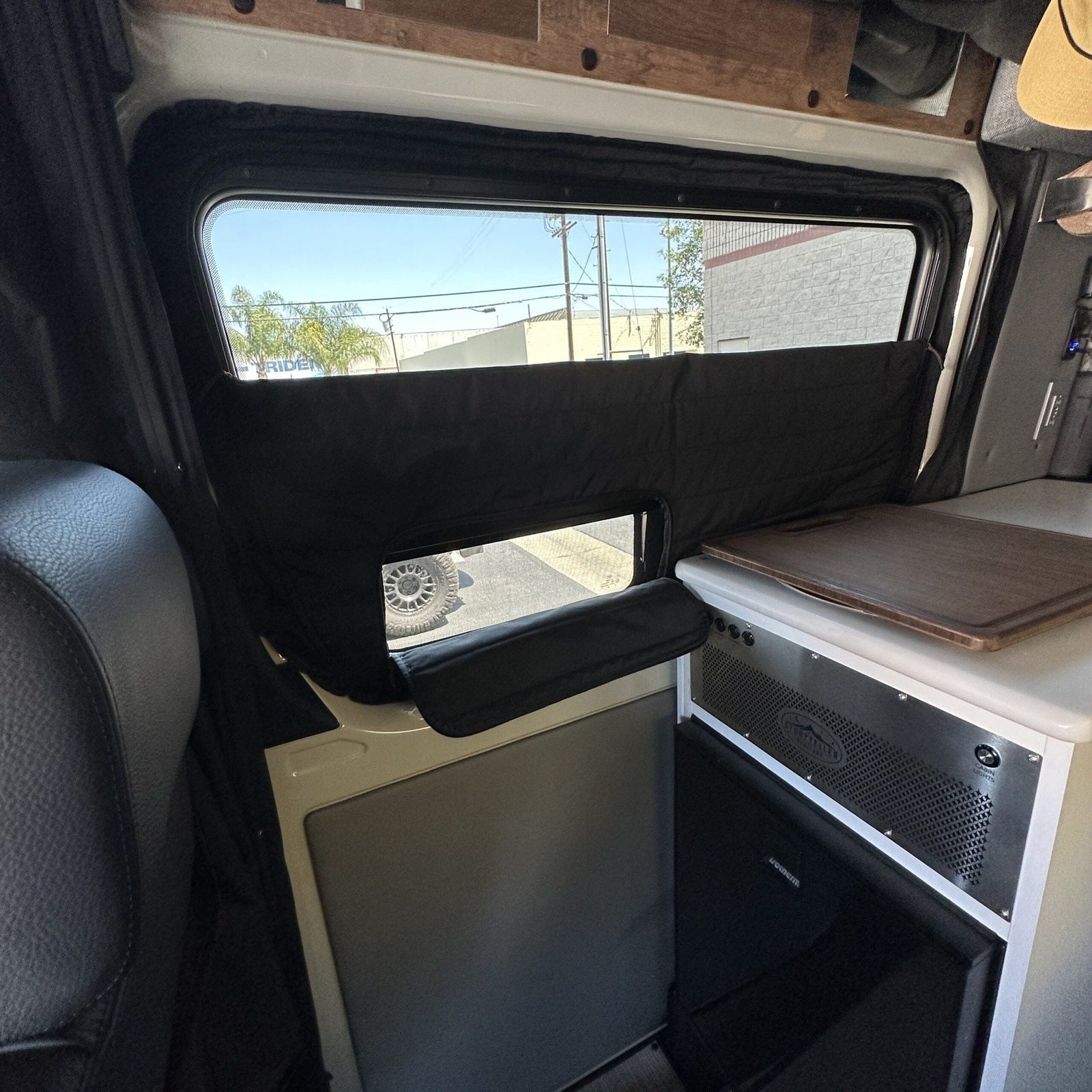 Canyon Adventure Vans CLIMA-SHADE insulated sliding door window cover for Storyteller Overland Mode vehicle, installed on window.