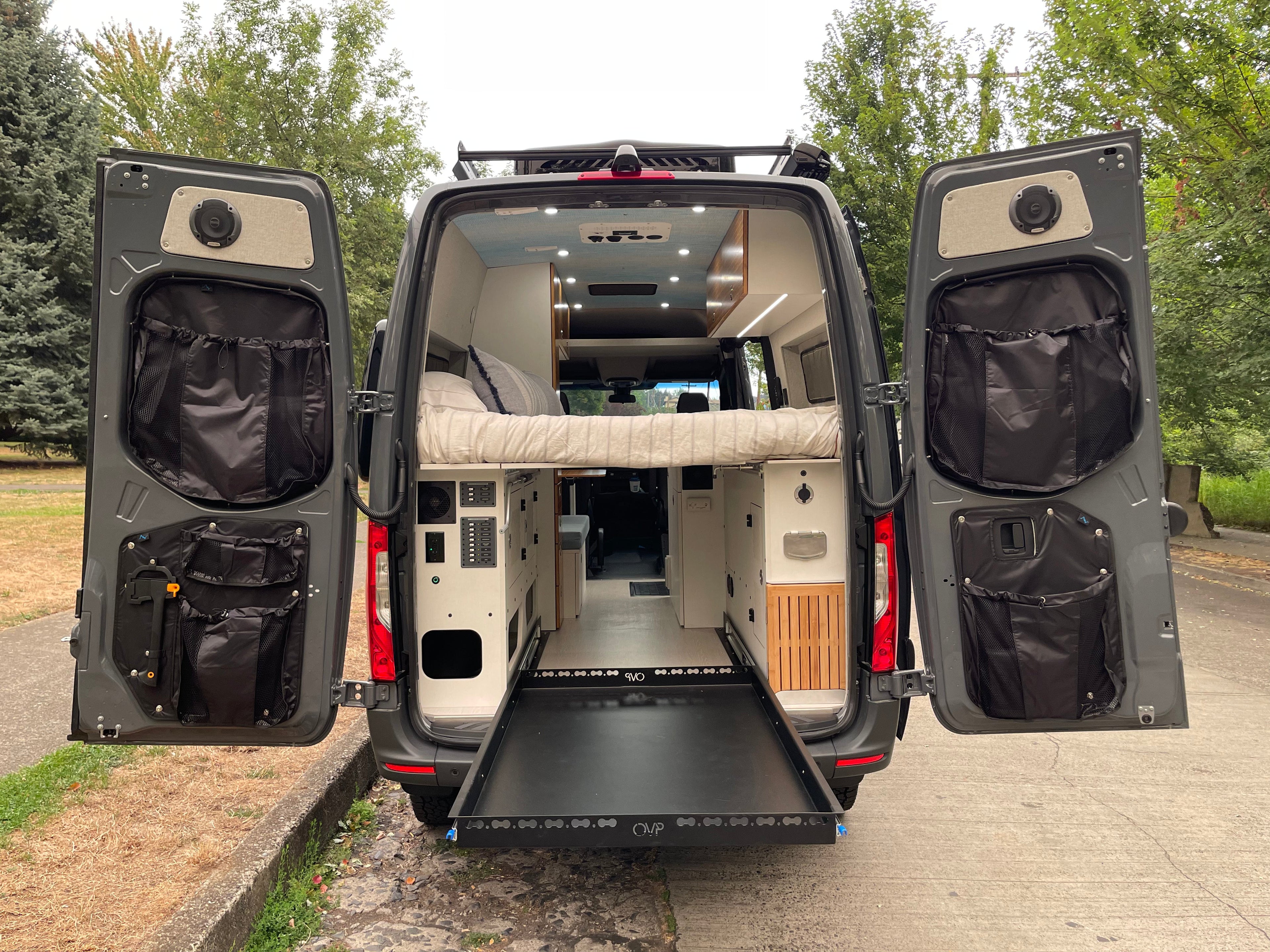 Alpine Van Works AVW Mid-Door Bags for storage solutions, shown hanging inside a vehicle with organized compartments.