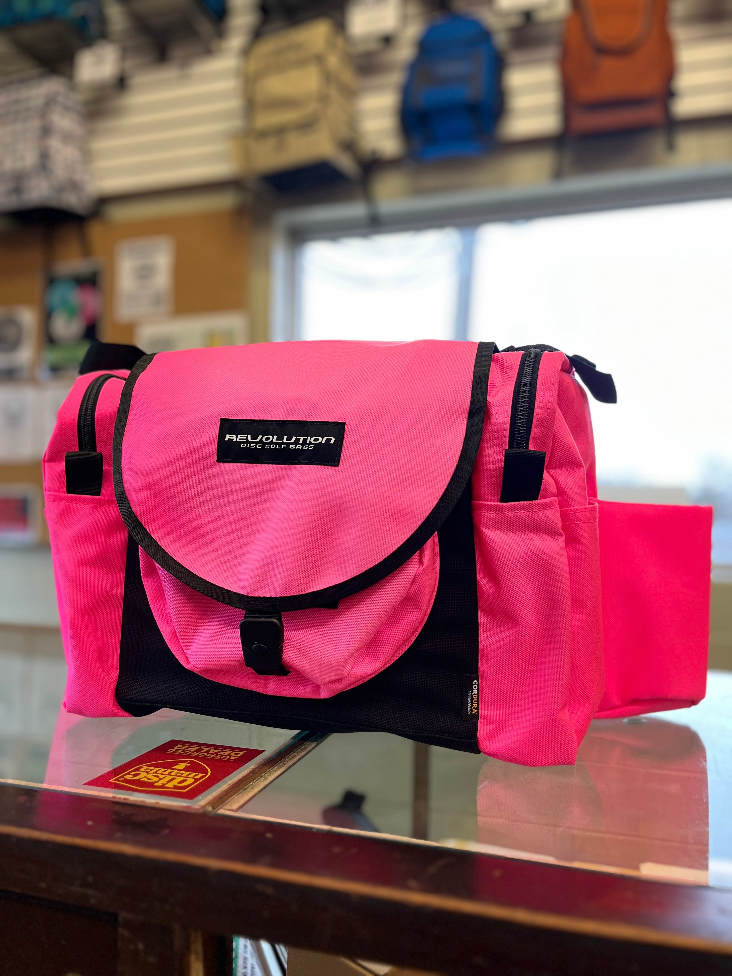 Gotta Go Gotta Throw Revolution Carolina Team V3 disc golf bag in brilliant rose with multiple compartments and adjustable straps.