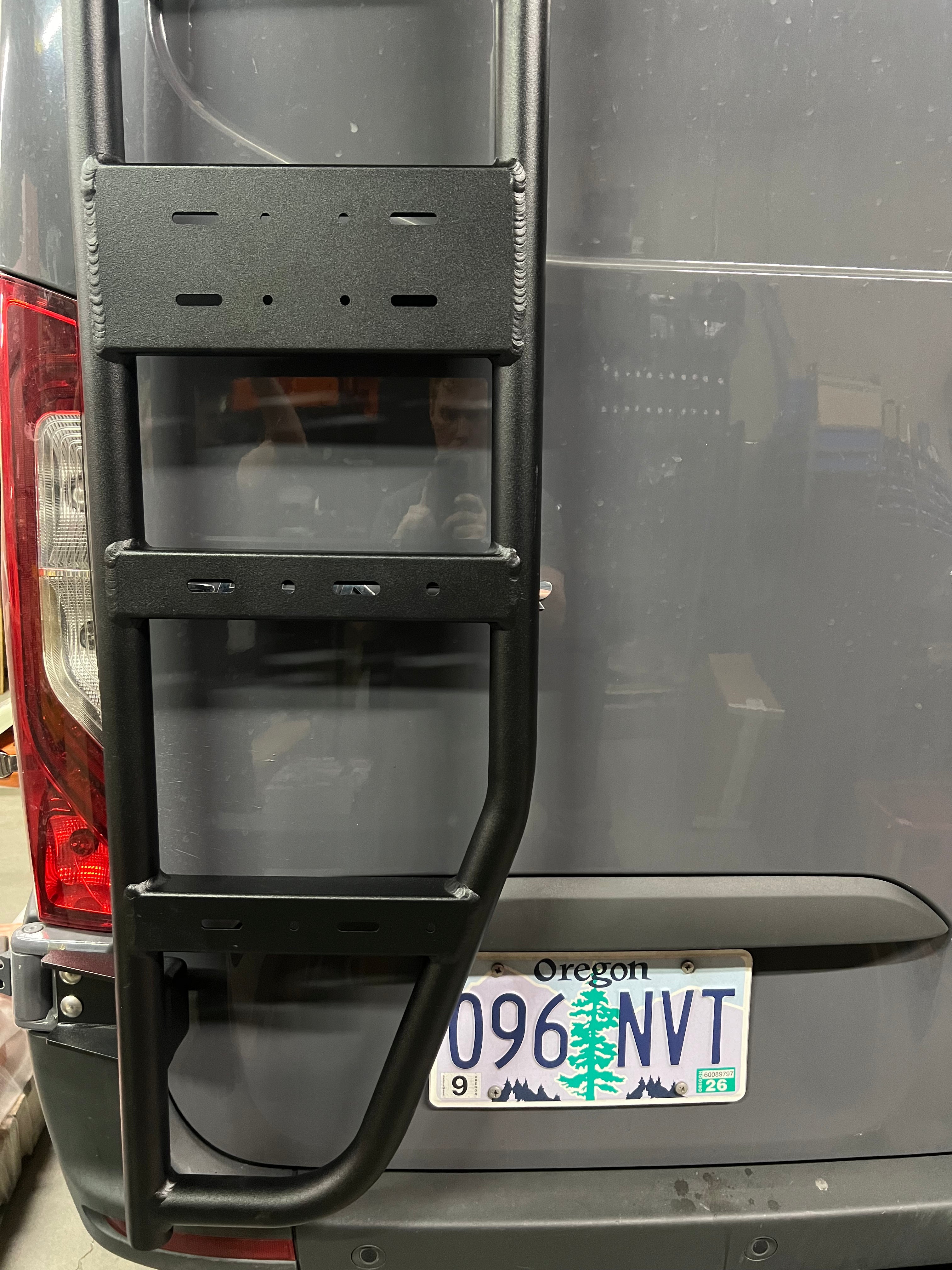 Avatar Offroad Sprinter Van Rear Ladder mounted on the back of a van for easy roof access. Durable metal construction.