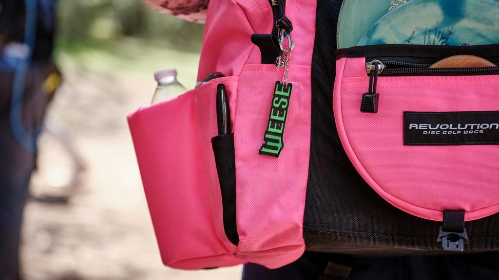 Gotta Go Gotta Throw Revolution Mini Deluxe V3 disc golf bag in Brilliant Rose with multiple compartments and adjustable straps.